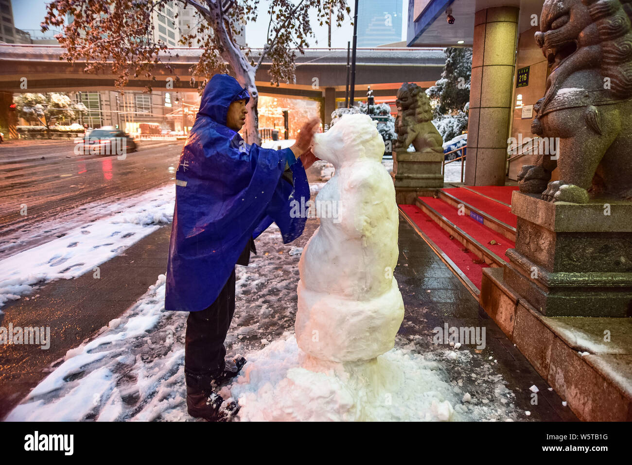 Chinesische bank Security Guard zunamen Du macht einen Schnee Skulptur mit der Form von Zhu Bajie, ein Charakter aus der Chinesischen klassischen Reise in die W Stockfoto