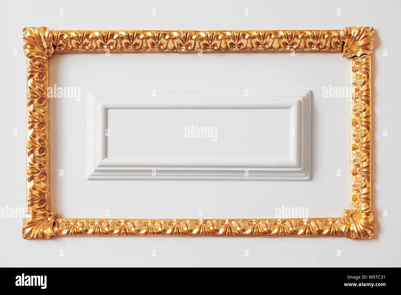 Klassischen und luxuriösen Interieur Fragment, weiße Wand Dekoration Element mit goldenen geschnitzten Rahmen Stockfoto