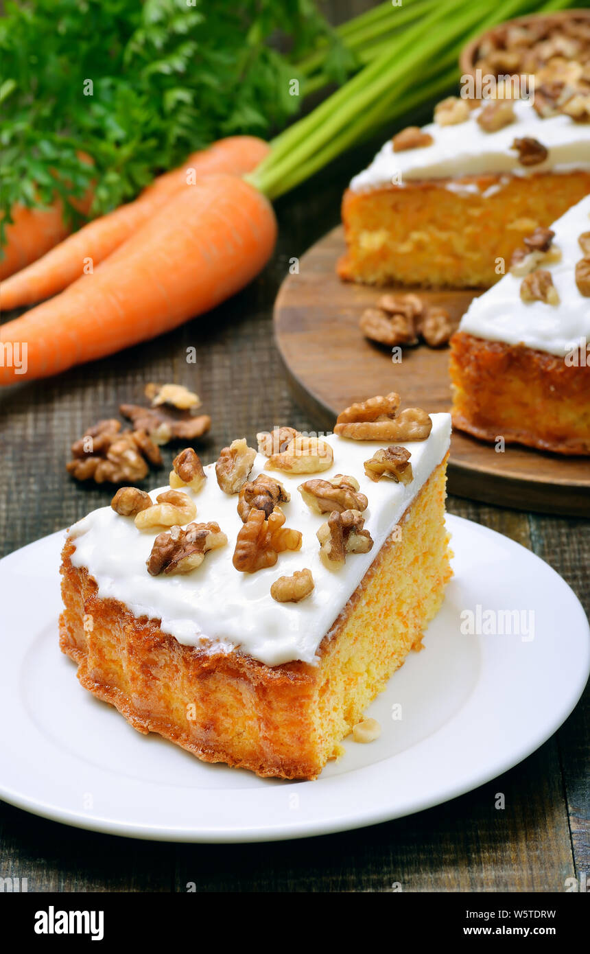 Hausgemachte Stück Karottenkuchen mit Zuckerglasur dekoriert Nussbaum Stockfoto