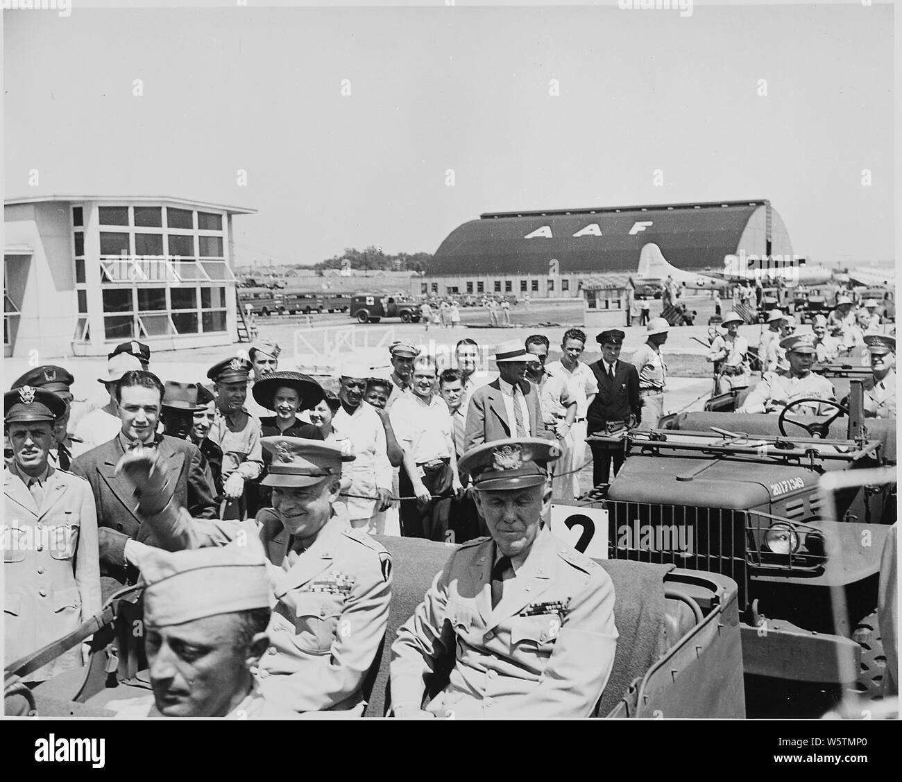 Foto von General Dwight D. Eisenhower in der Rückseite eines Jeep mit General George Marshall und winkte den Zuschauern am Flughafen in Washington. Stockfoto