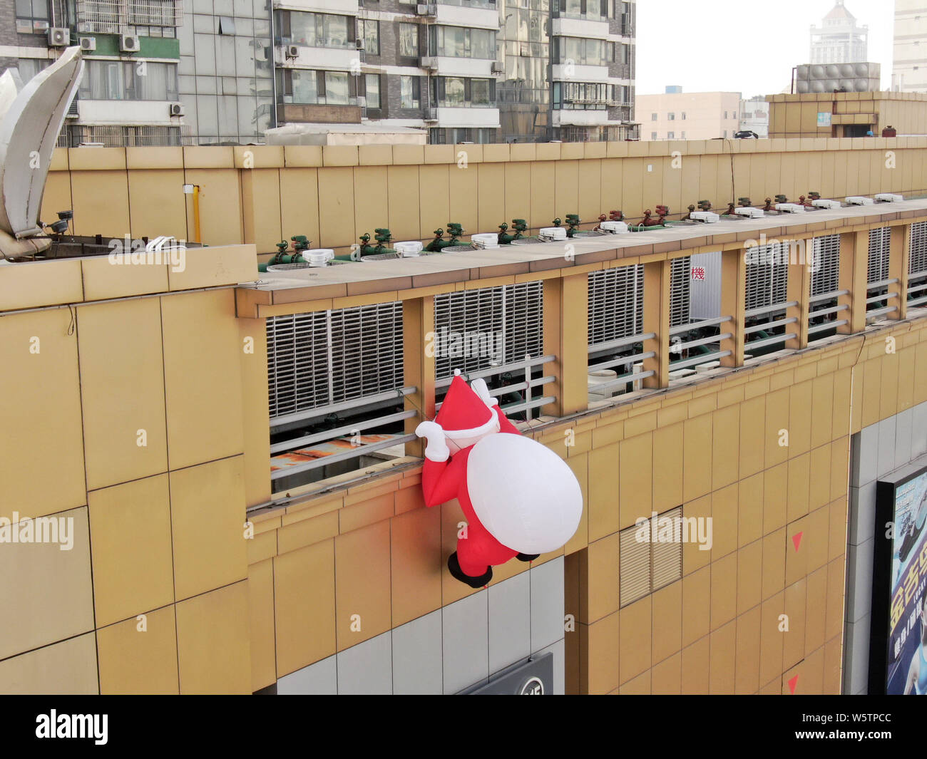 Ein Spielzeug ballon Santa Claus mit einem riesigen geschenkbeutel Klettert die Wand eines Kaufhauses in Nantong City, der ostchinesischen Provinz Jiangsu, 1. Dezem Stockfoto