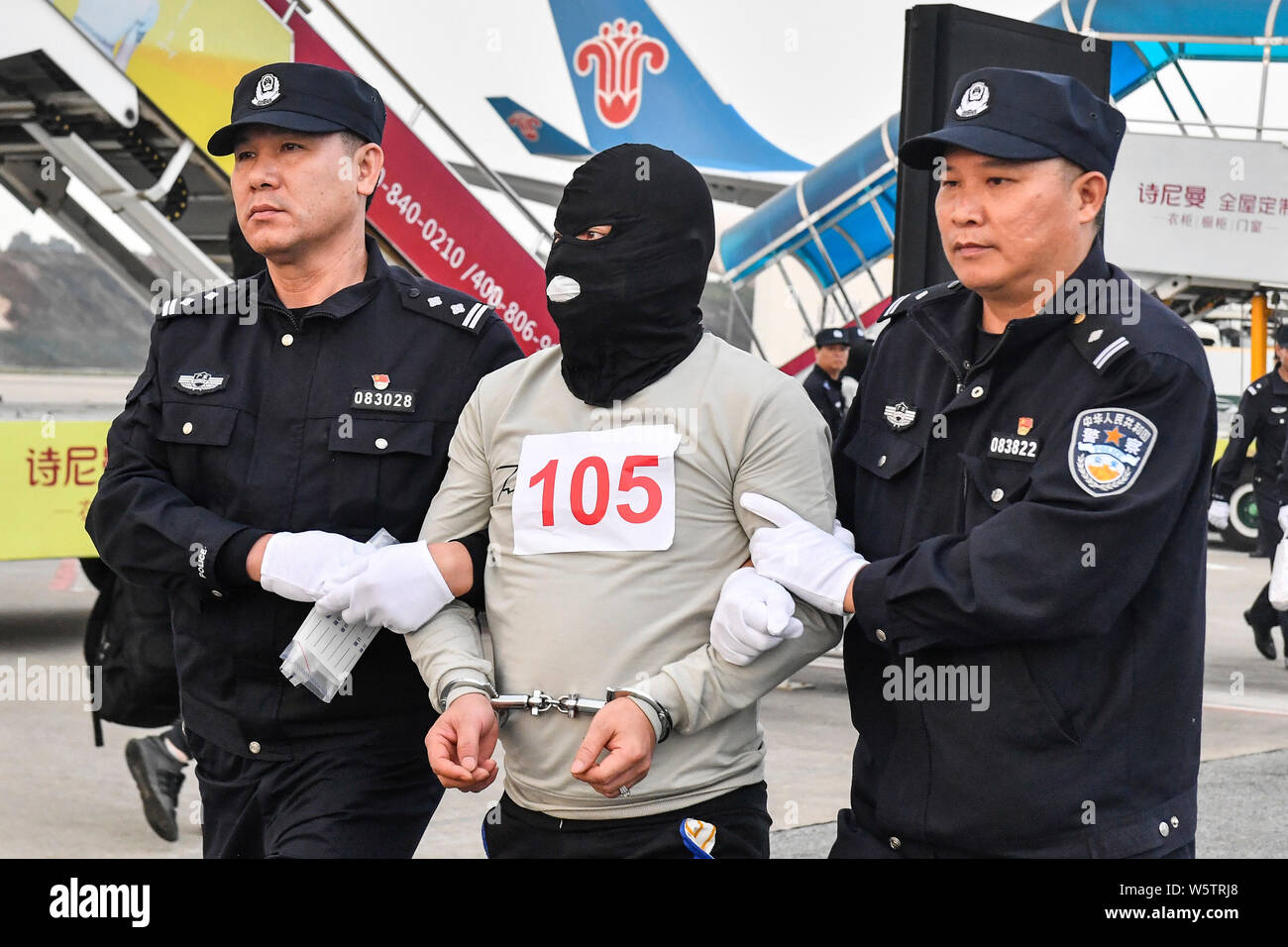 Chinesische Verdächtige für Cross-border telecom Betrug durch chinesische Polizisten begleitet, wie sie sich aus Kambodscha zurück und kommen an der Stockfoto