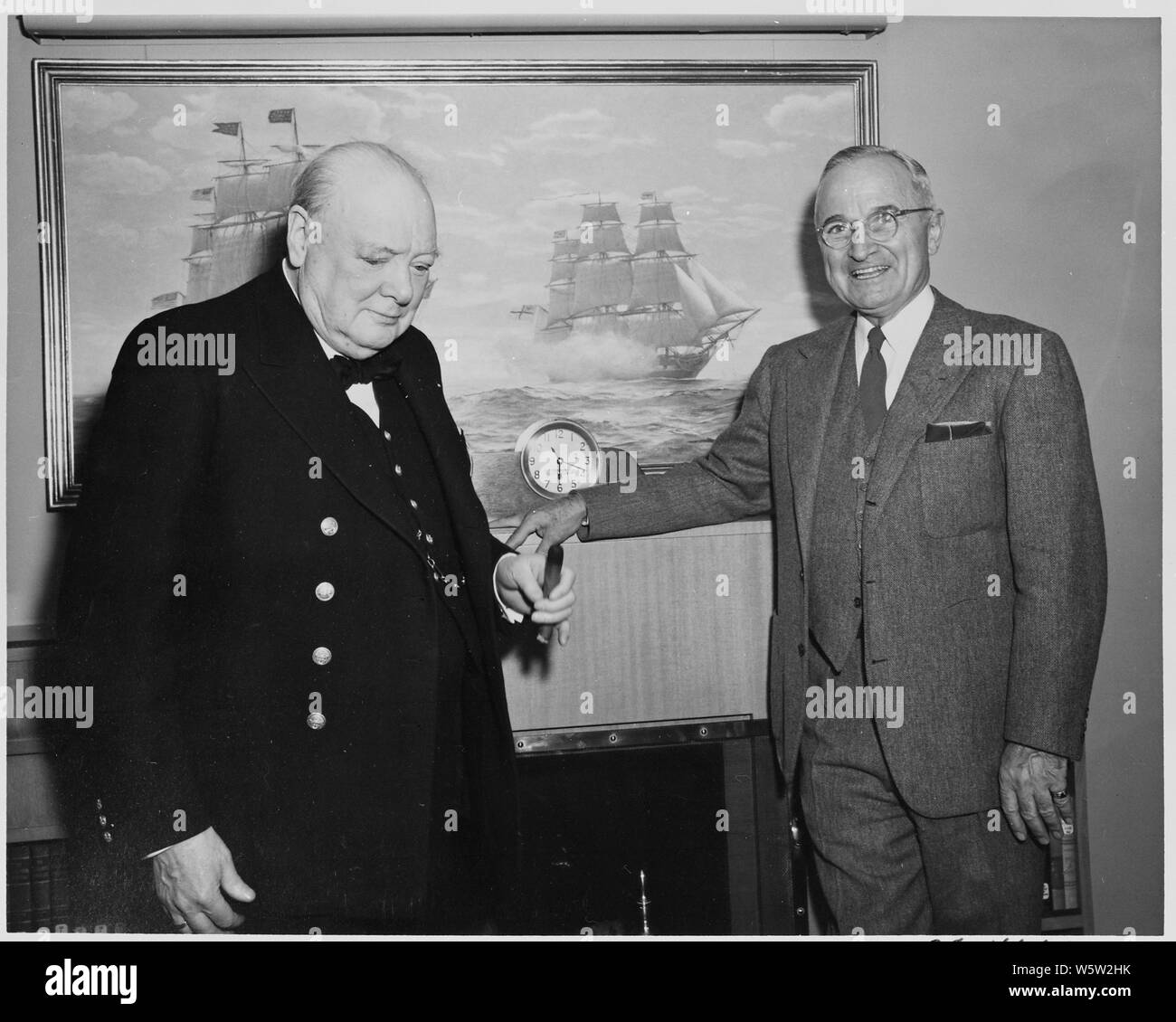 Foto von Präsident Truman und der britische Premierminister Winston Churchill an Bord der Yacht des Präsidenten, die U.S.S. WILLIAMSBURG, vor einem Gemälde der Engagement zwischen der U.S.S VERFASSUNG und H.M.S JAVA während des Krieges von 1812. Stockfoto