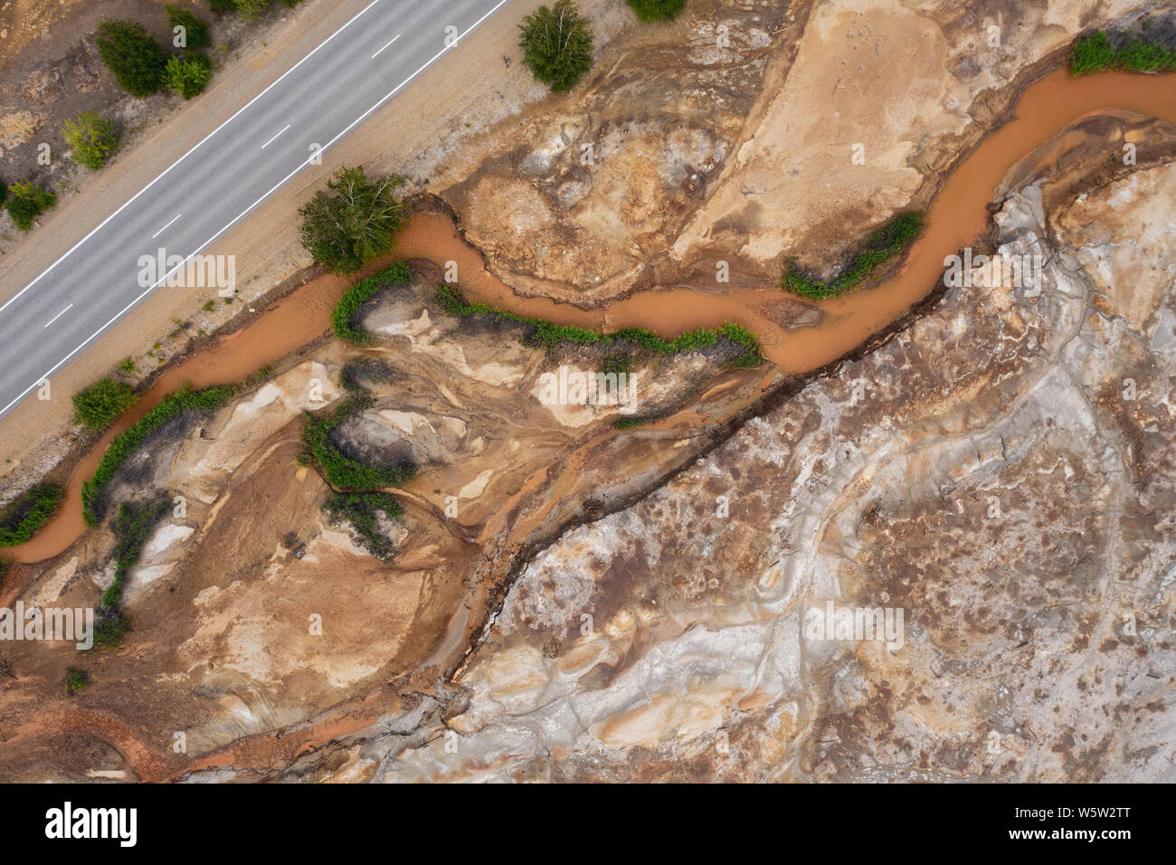 Luftaufnahme; Drohne Fliegen in einer verschmutzten Fluss mit zerstört Ökosystem und Kupfer tailing dump Vergiftung Boden und Wasser; Luft Emissionen her Stockfoto