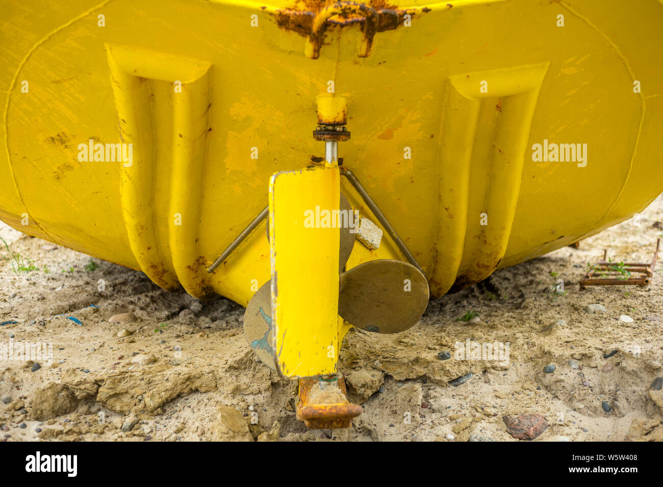 Hinten ein Fischerboot am Strand liegt. Das seitenruder und die Propeller sind deutlich sichtbar. Chlopy, Polen 2019. Stockfoto
