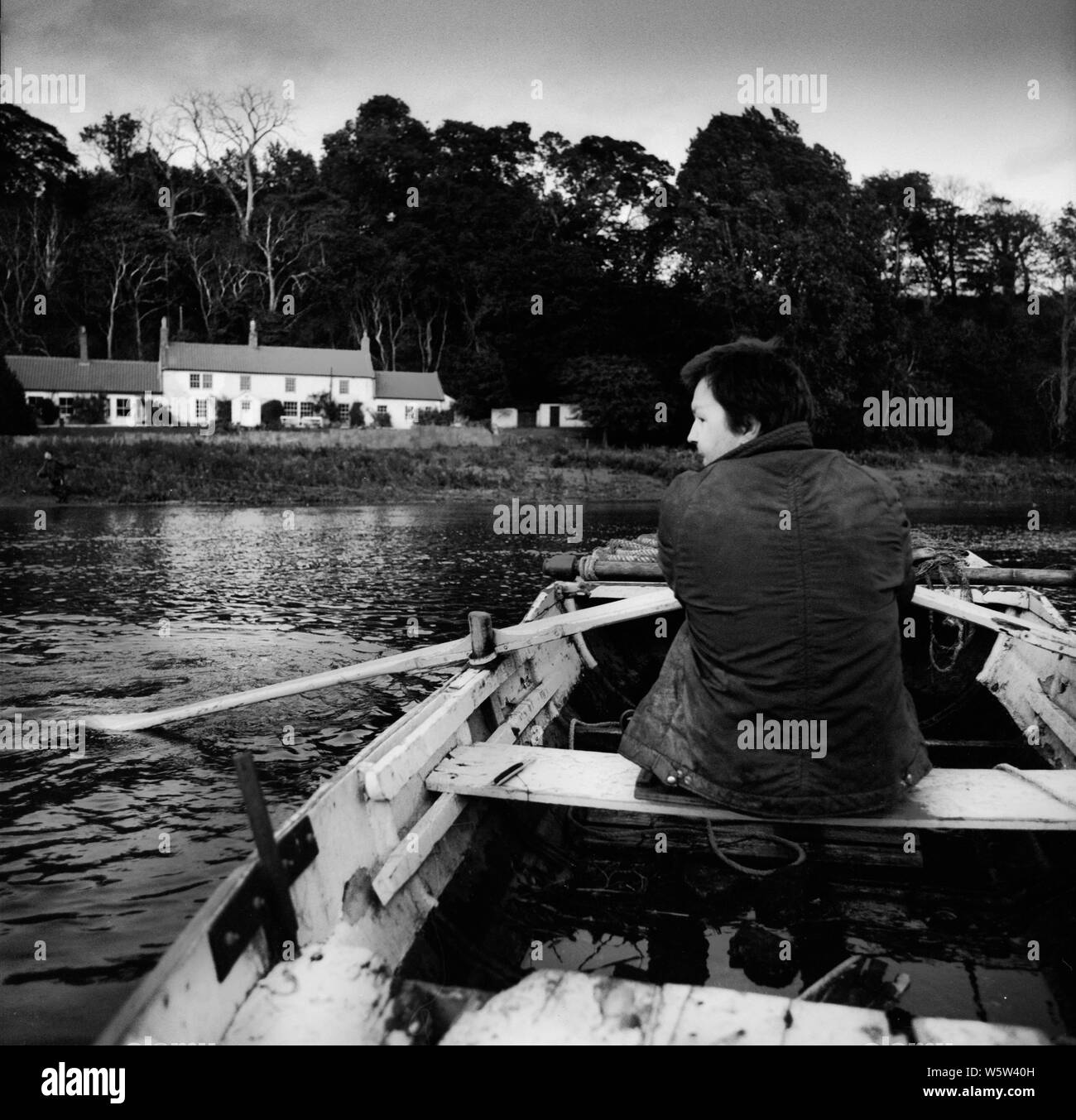 Colin Wharton rudern einen Schuß an Canny Fischerei auf dem Fluss Tweed an norham Bootshaus in den späten 1980er Jahren Stockfoto