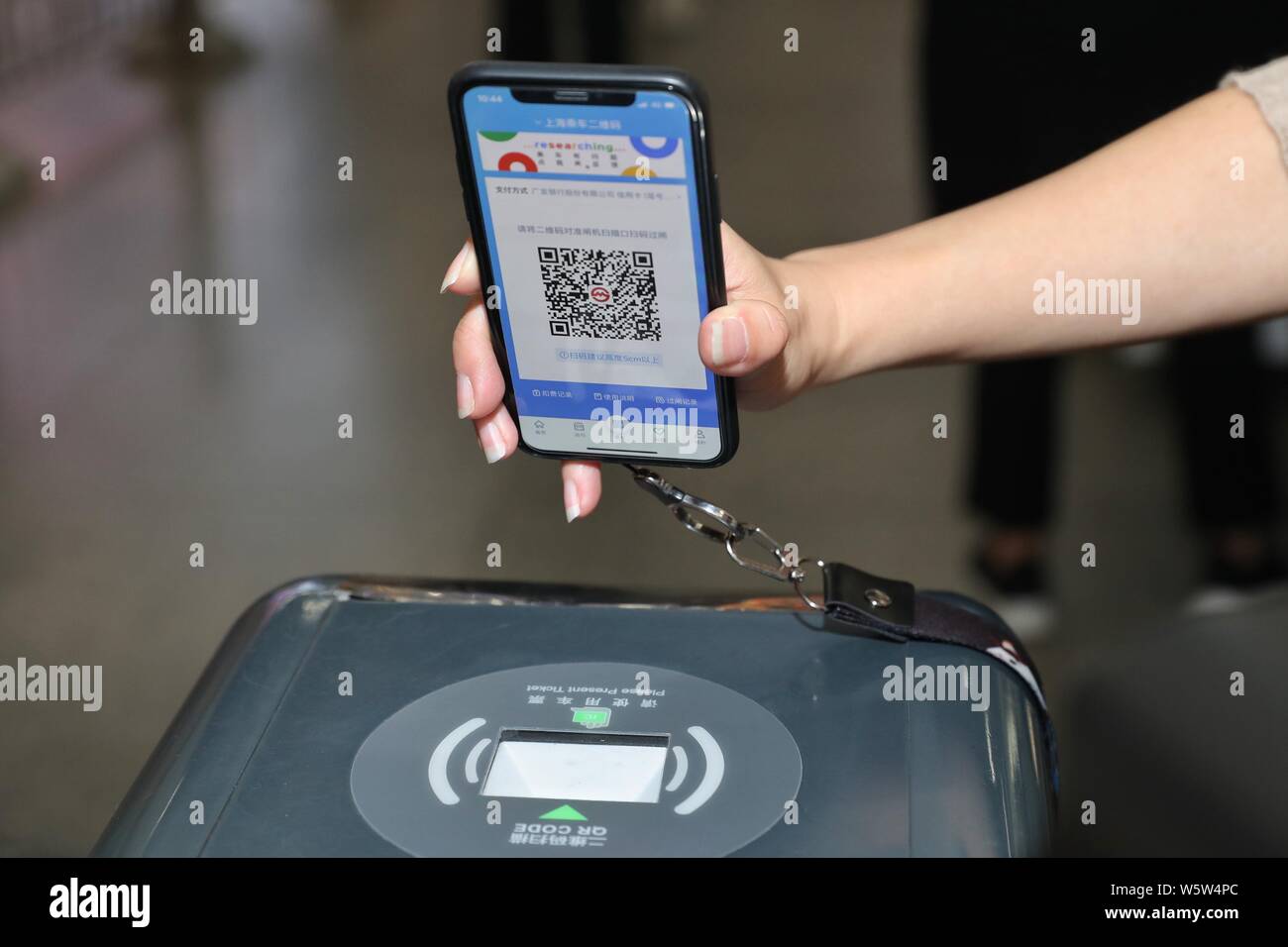 Ein Fluggast, stellt Ihr Smartphone über ein Drehkreuz für den QR-Code auf  der Metro Daduhui app gescannt für U-Bahn Ticket über Alipay zu bezahlen  und t eingeben müssen Stockfotografie - Alamy