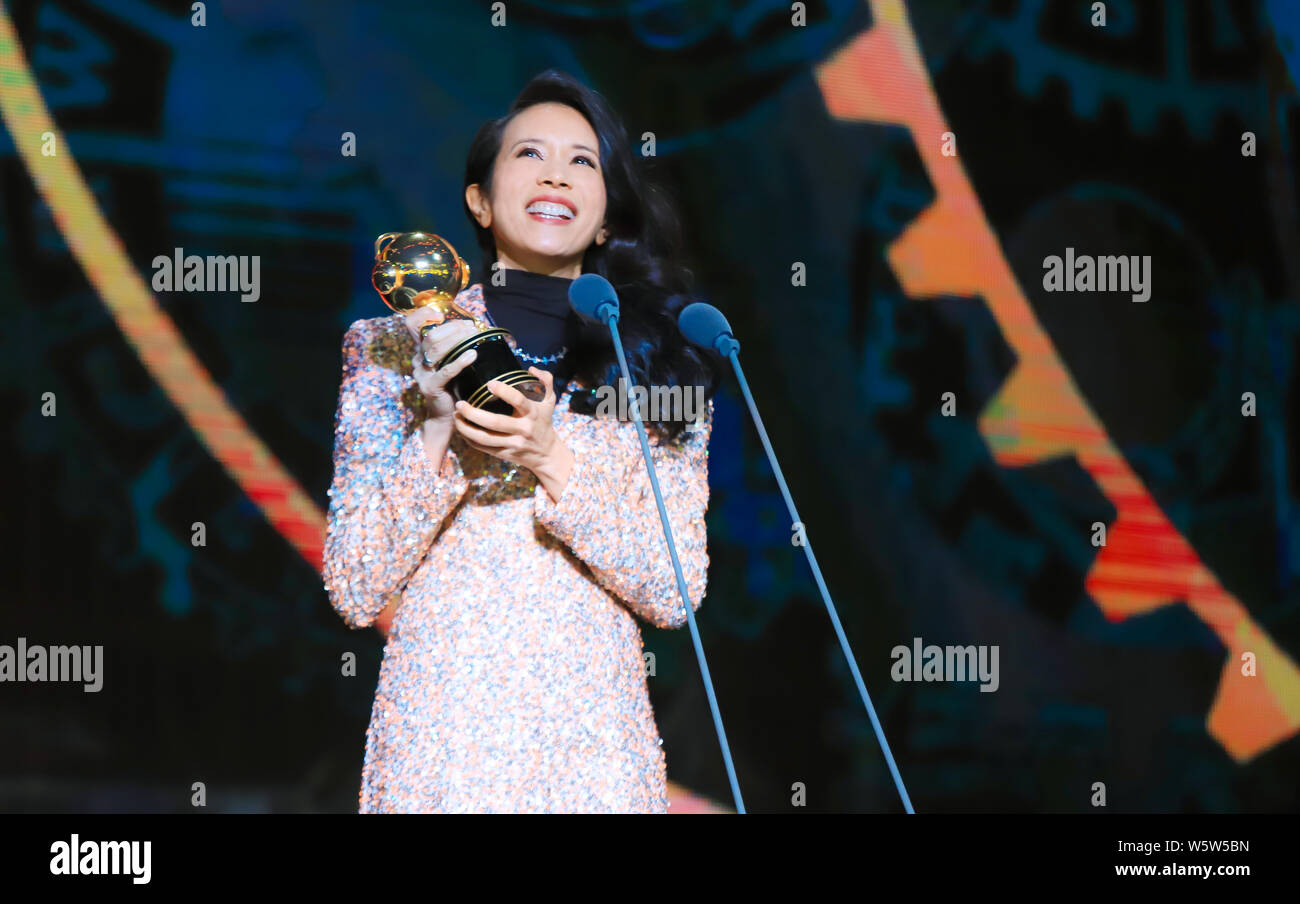 Hong Kong Sängerin und Schauspielerin Karen Mok wirft mit der Trophäe für den 'Most Beliebte Sängerin (Hongkong/Taiwan)' Award am 12. migu Musik Awar Stockfoto