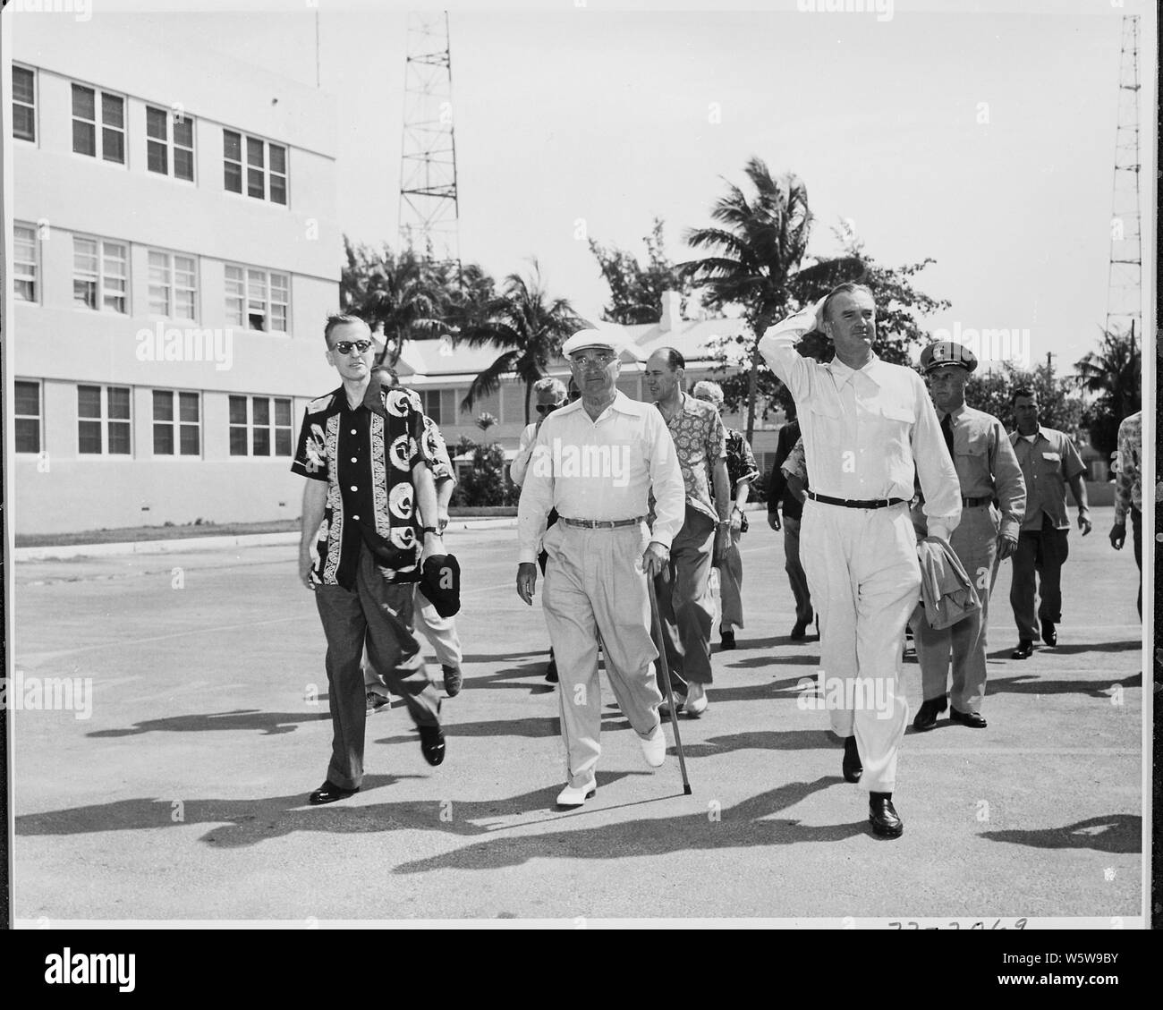 Foto von Präsident Truman zu Fuß zum Strand am Morgen während seines Urlaubs in Key West, Florida, mit der wirtschaftlichen Stabilisierung Administrator Eric Johnston (links), Vorsitzender W. Stuart Symington der National Security Resources Board (rechts), und andere Mitglieder seiner Entourage. Stockfoto