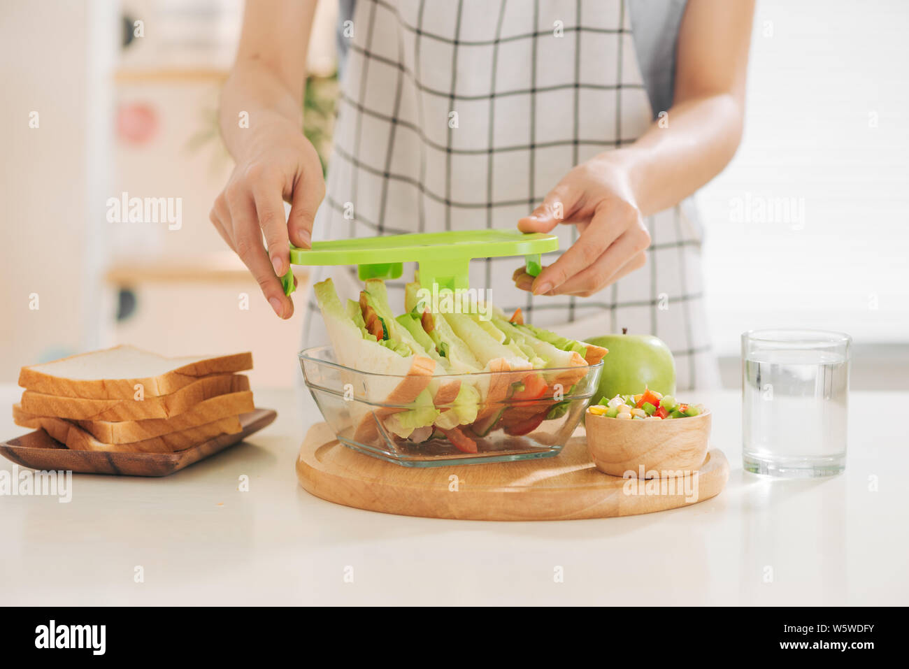 Mutter vorbereiten Sandwich für Schule Mittagessen auf dem Tisch Stockfoto