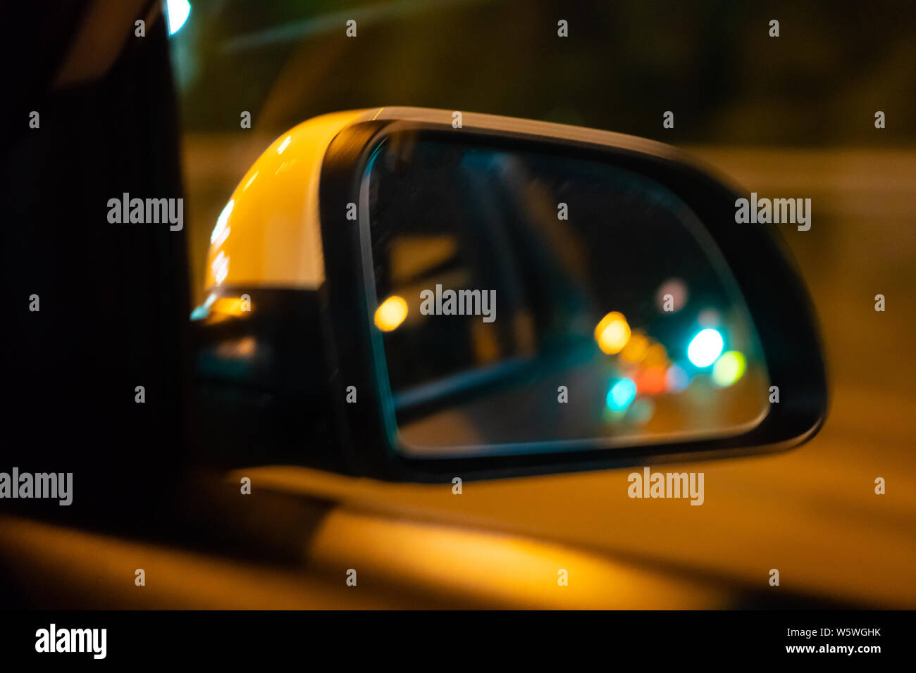 Landschaft in der Seitenansicht Spiegel der ein Auto in der Nacht, in der  Straße. In die Außenspiegel des Autos ist die Lichter der Nacht Stadt wider  Stockfotografie - Alamy