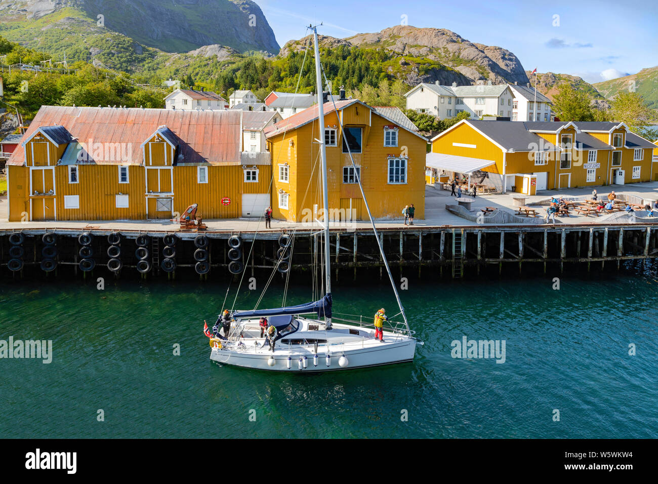 Yacht verlassen Nusfjord Hafen, auf der Insel Flakstadøya, in der Inselgruppe Lofoten, nördlich des Polarkreises, Nordland, Norwegen. Stockfoto