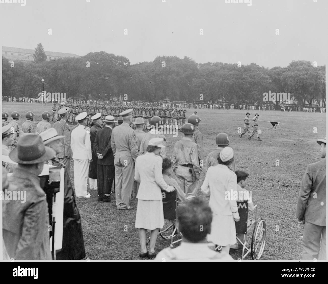 Foto des japanisch-amerikanischen 442Nd Regimental Combat Team vorbei Bewertung für Präsident Truman, andere Würdenträger und verwundeten Soldaten im Rollstuhl. Stockfoto