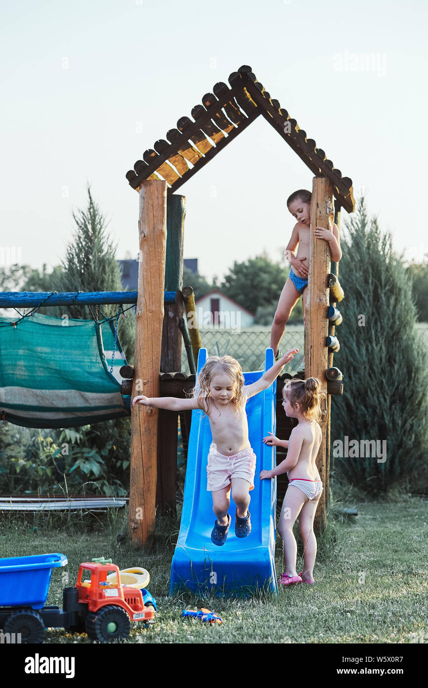 Kinder spielen zusammen auf einem Spielplatz im heißen Sommer Urlaub Tag. Ehrliche Menschen, echte Momente, in authentischen Situationen Stockfoto