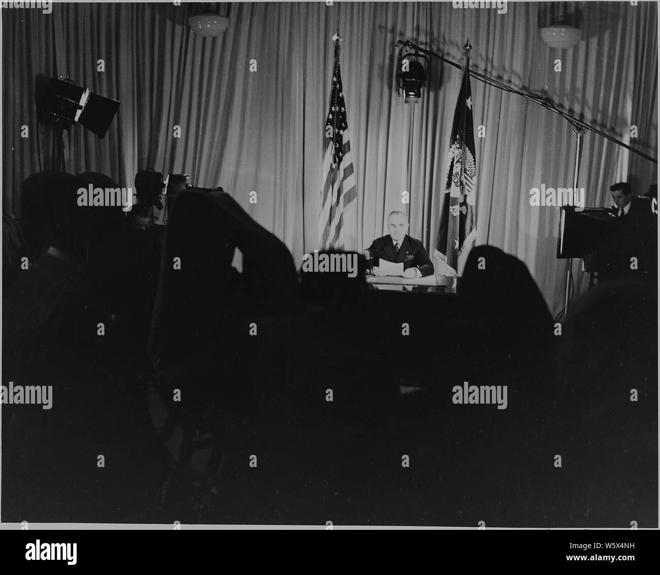 Präsident Harry S. Truman am Schreibtisch sitzt, Lichter, Kameras rollen, die Ankündigung, dass der Zweite Weltkrieg in Europa beendet ist. Stockfoto