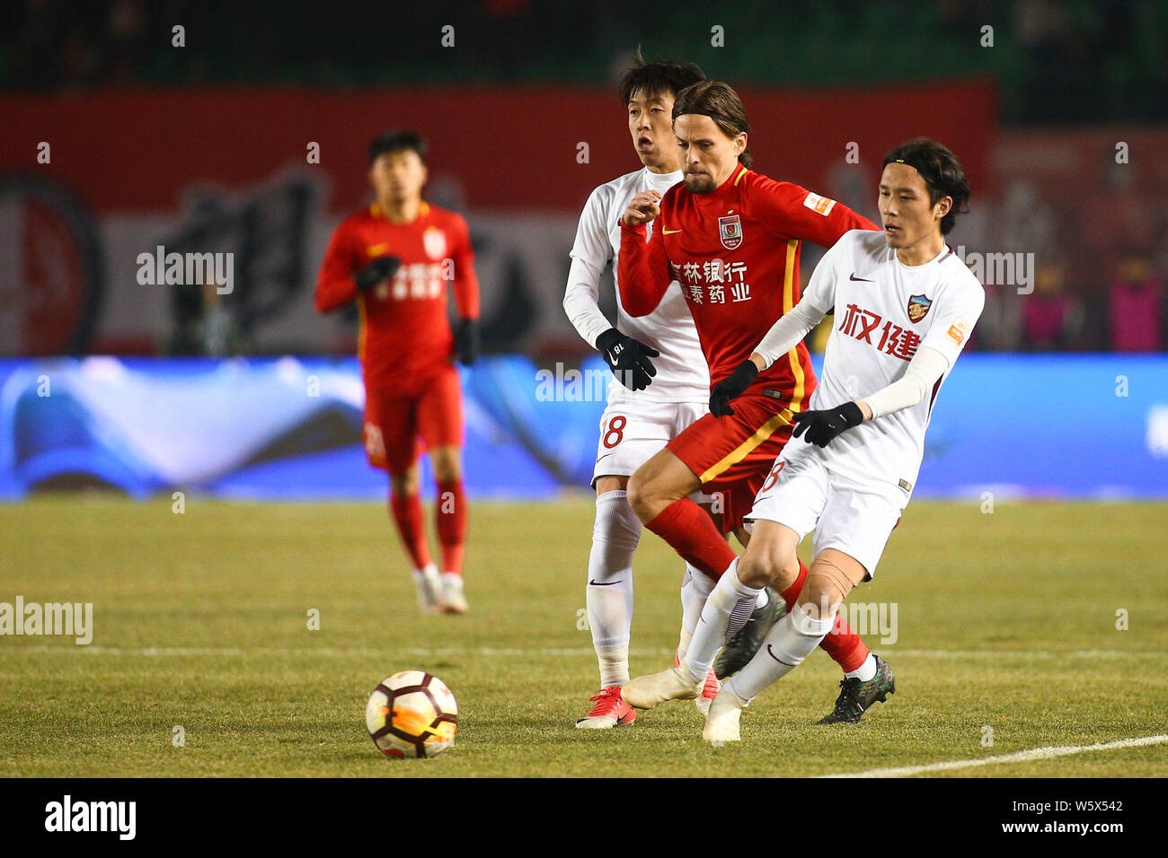 Dänischer Fußballspieler Lasse Vibe, Mitte, Changchun Yatai den Ball gegen Spieler von Tianjin Quanjian in der 29. Runde während des 2. Stockfoto