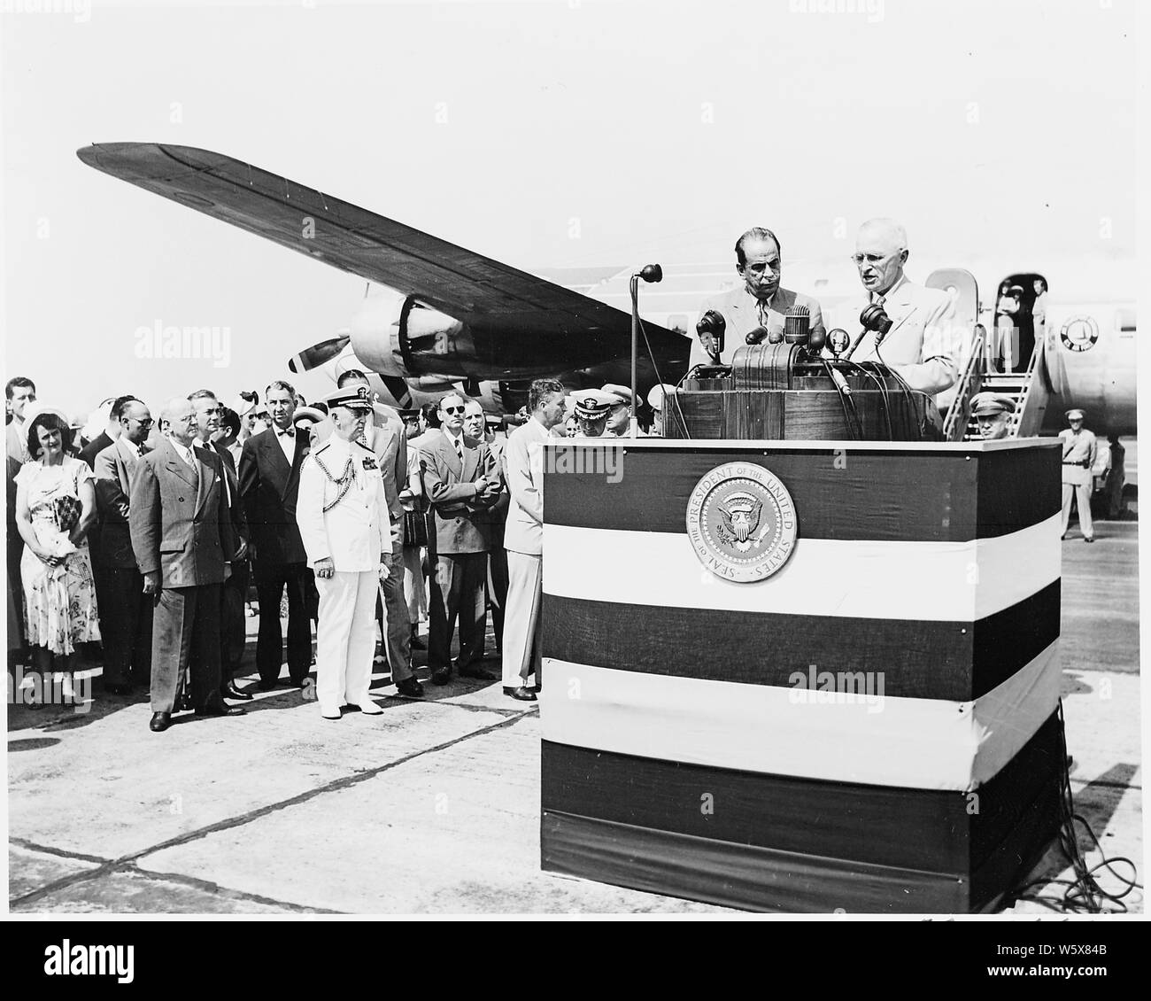 Präsident Truman und Präsident Romulo Gallegos Venezuela auf dem Podium während einer Zeremonie am Flughafen nach der Ankunft des Präsidenten Gallegos für einen Besuch in den Vereinigten Staaten. Die Presidential Flugzeug Unabhängigkeit im Hintergrund ist. Admiral William Leahy ist auf der linken Seite des Podiums. Stockfoto