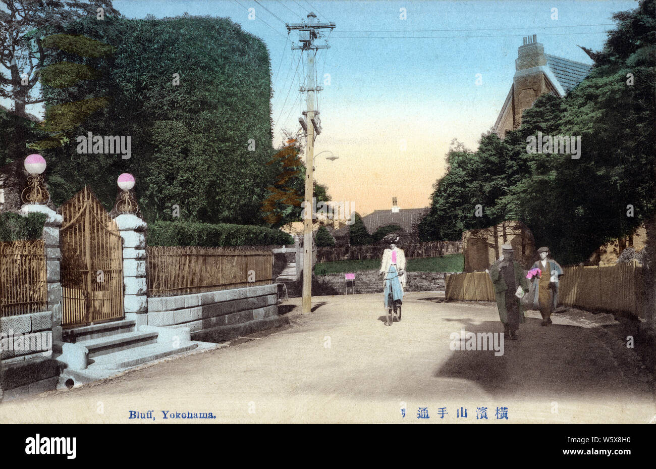 [1900s Japan - Ausland Viertel, Yokohama] - eine fremde Frau auf einem Fahrrad Zyklen auf einer Straße mit Western style Residences at Yamate (auch bekannt als Bluff) in Yokohama, Kanagawa Präfektur. 20. jahrhundert alte Ansichtskarte. Stockfoto
