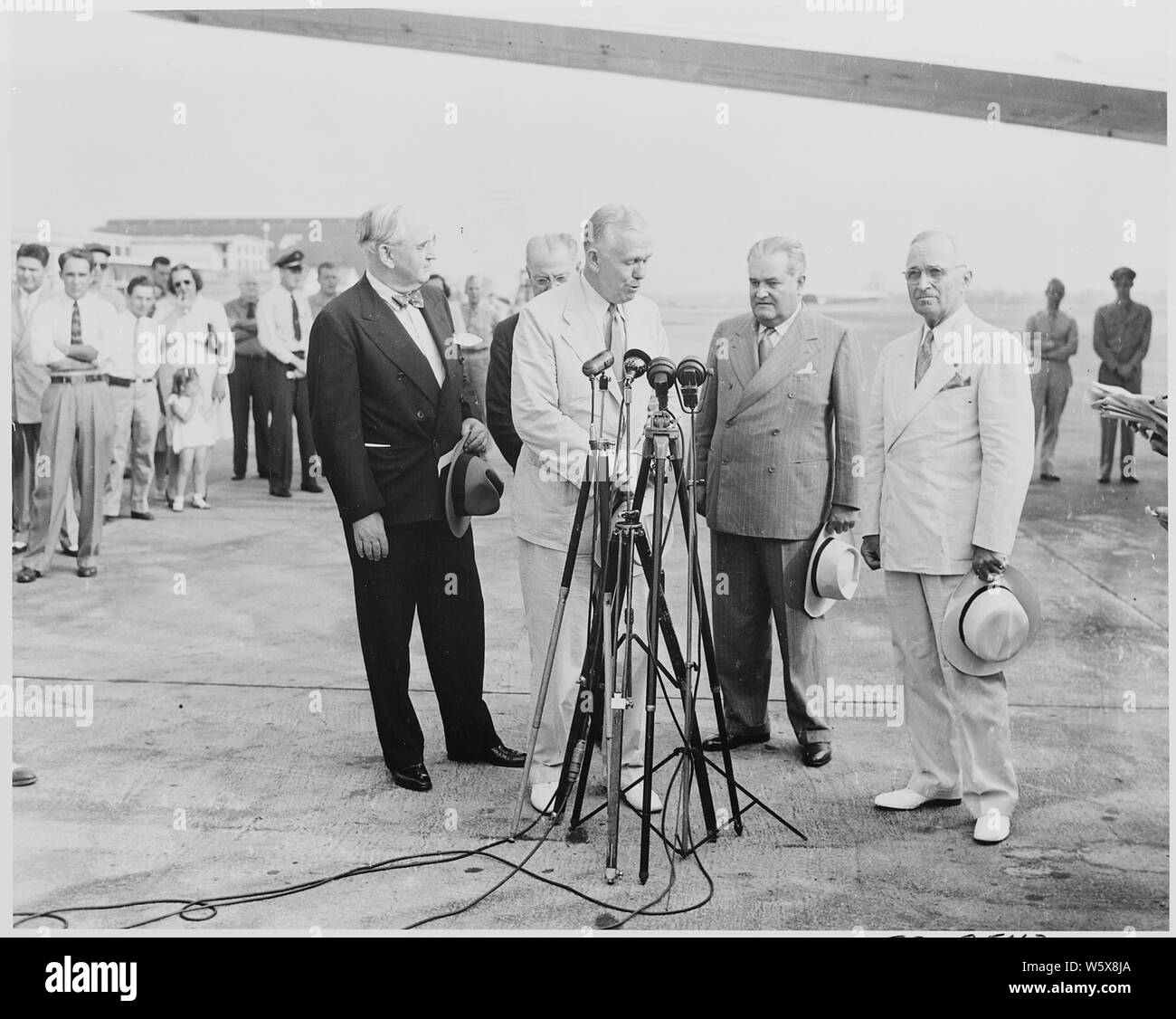 Präsident Truman am National Airport in Washington, D.C., wo er weg ist, Außenminister George Marshall und zwei Delegierte, die verlassen sind die Rio de Janeiro Konferenz der Außenminister in Brasilien zu besuchen. L bis R auf Mikrofone: Sen. Arthur Vandenberg, Außenminister Marshall, brasilianischen Botschafter Carlos Martins, und Präsident Truman. Stockfoto