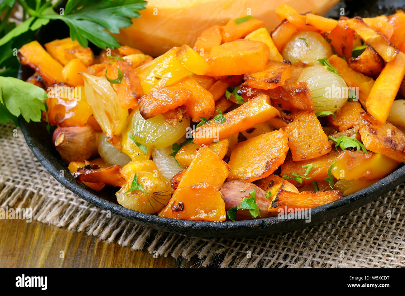 Gebratener Kürbis, Zwiebel, Knoblauch und Pfeffer in der Pfanne, Ansicht schließen Stockfoto