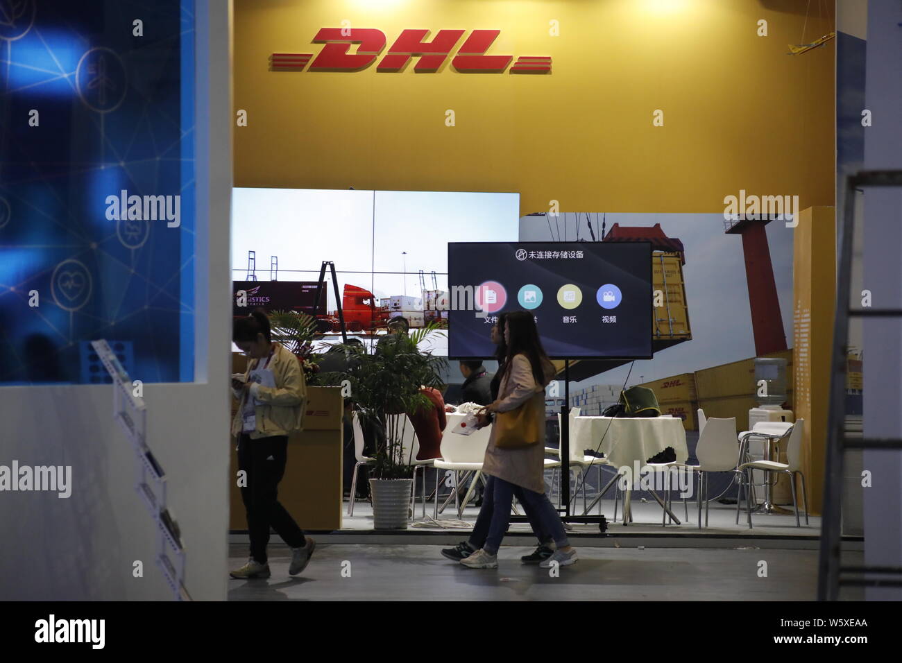 Chinesische Arbeiter sind am Stand der Deutschen Logistik Riese DHL Express vor dem Ersten China International Import Expo (CIIE) in Shanghai, Chi gesehen Stockfoto