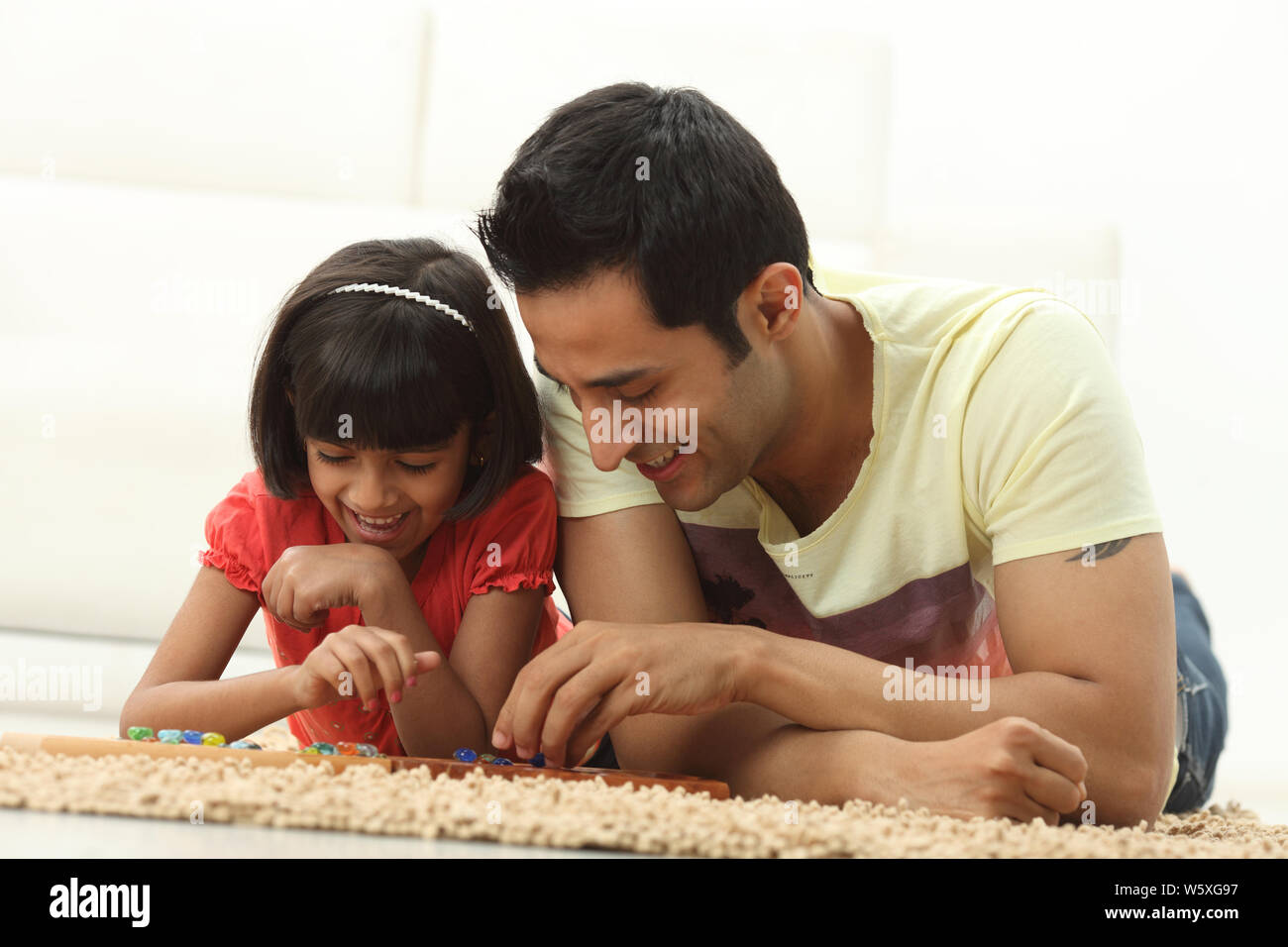 Mann mit seiner Tochter zu Hause Mancala-Spiel zu spielen Stockfoto