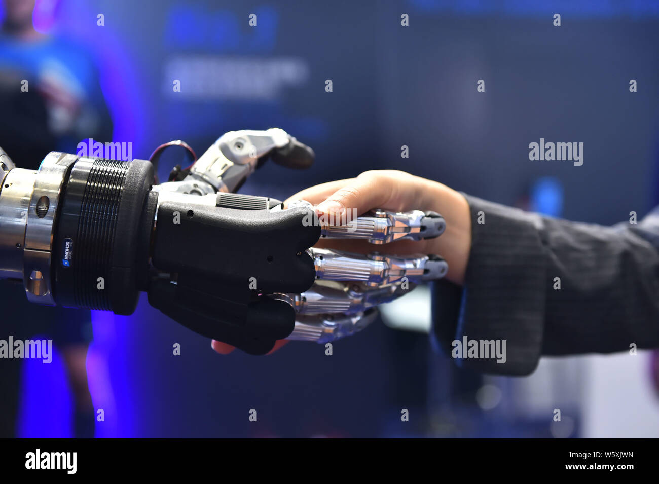 Ein Besucher schüttelt Hände mit einem Schunk 5-Finger greifen Hand für Serviceroboter entwickelt, während der ersten China International Import Expo (CIIE 2018) Stockfoto