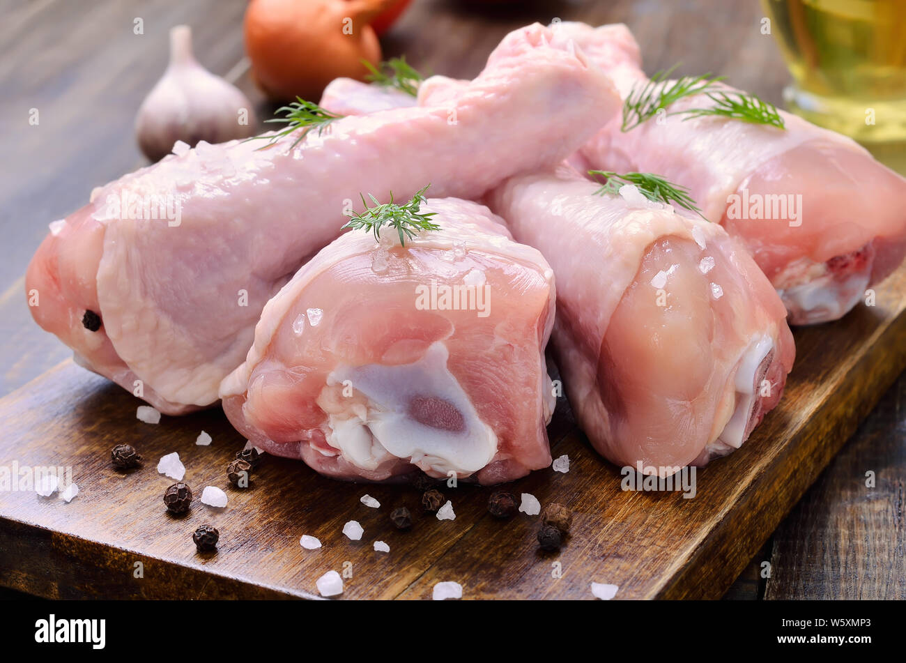 Raw Hähnchenschenkel und Gewürzen auf Holz Schneidebrett Stockfoto