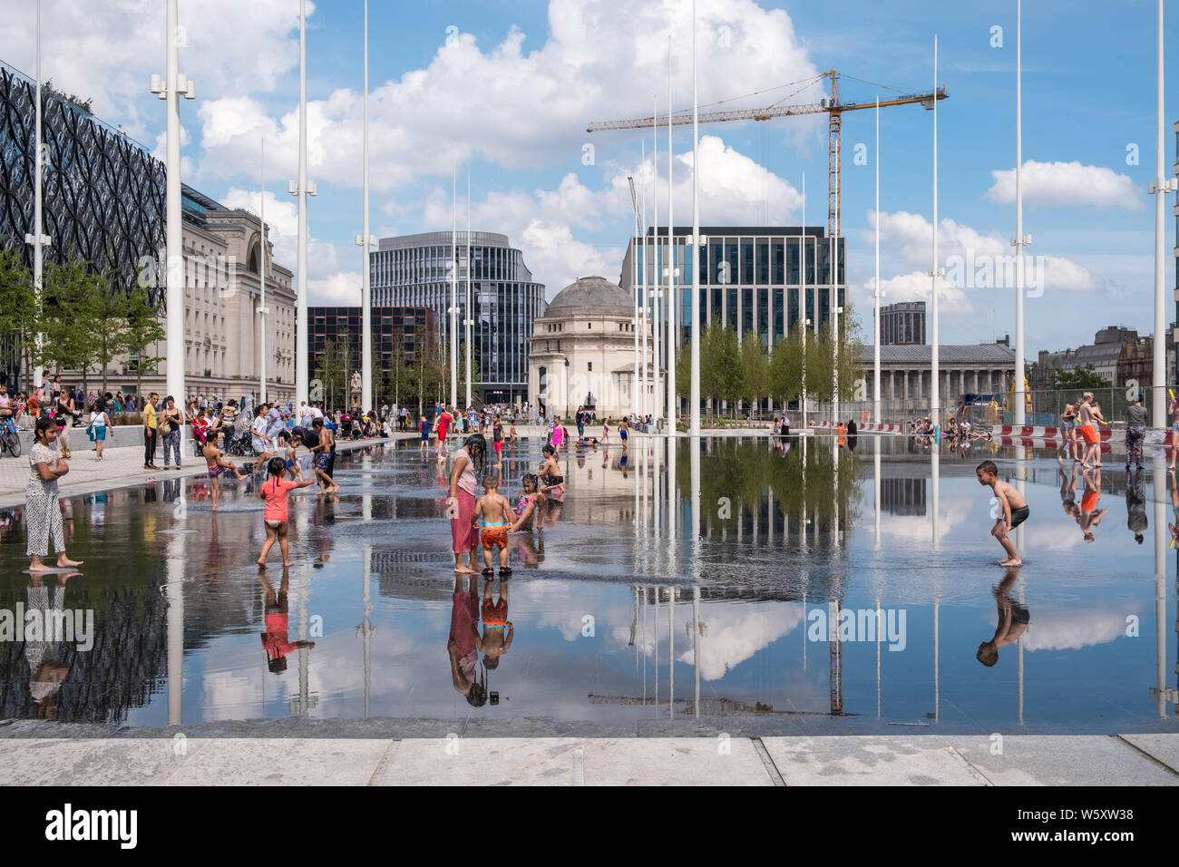 Kinder spielen und Abkühlen in den neuen Wasserspiel Spiegel und Brunnen in Centenary Square, Birmingham an einem heißen Tag Stockfoto