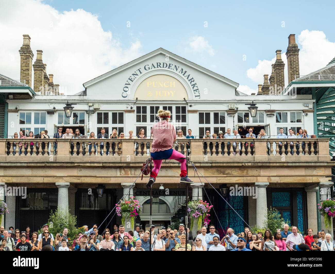 Zuschauer, die einen Street-Entertainer im Covent Garden, London, beobachten. Stockfoto