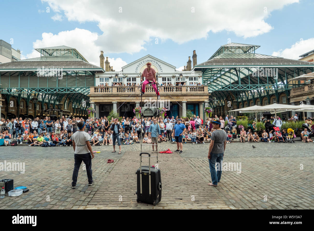 Zuschauer, die einen Street-Entertainer im Covent Garden, London, beobachten. Stockfoto
