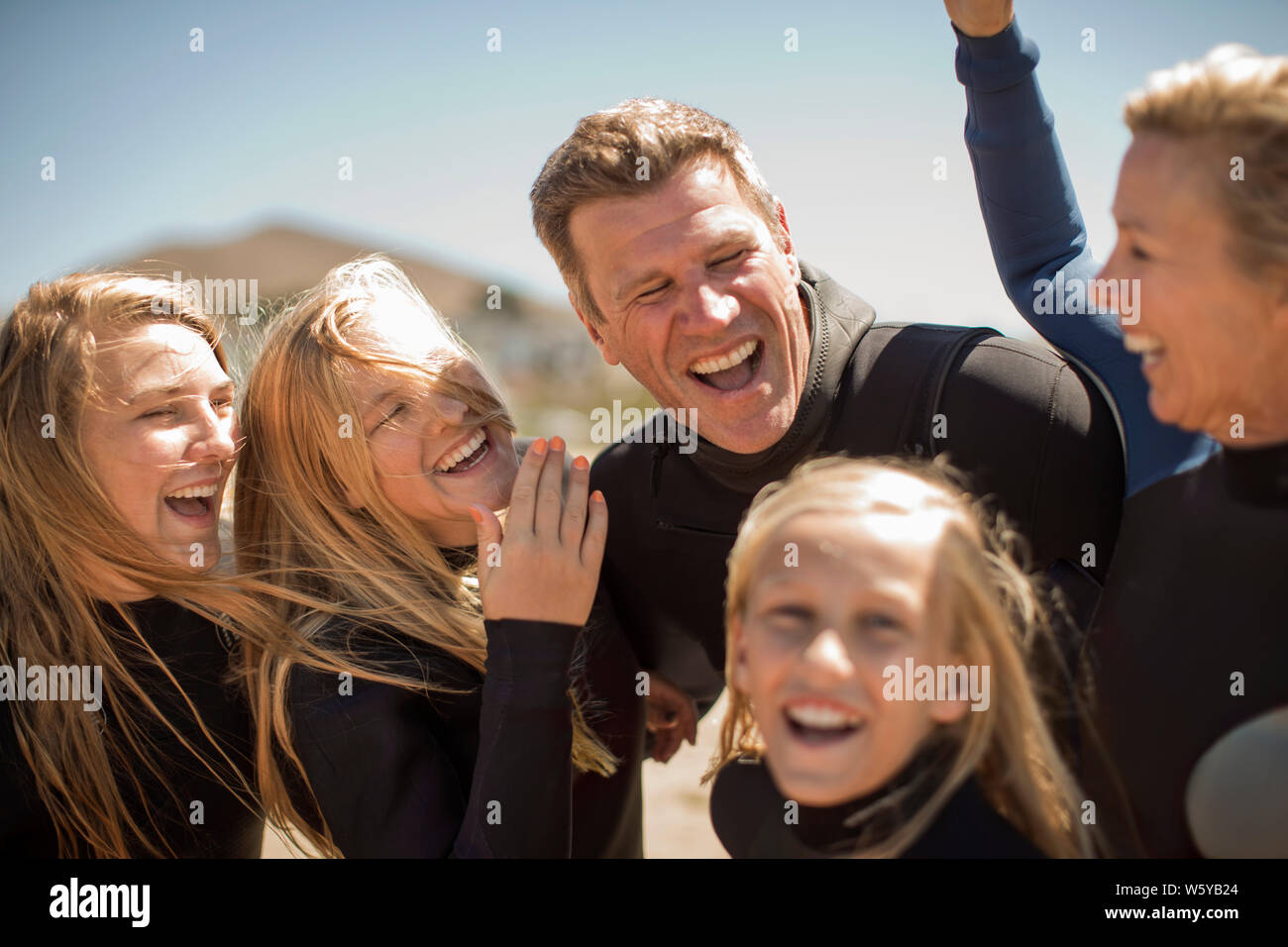 Lächelnd Familie am Strand Anzüge tragen. Stockfoto