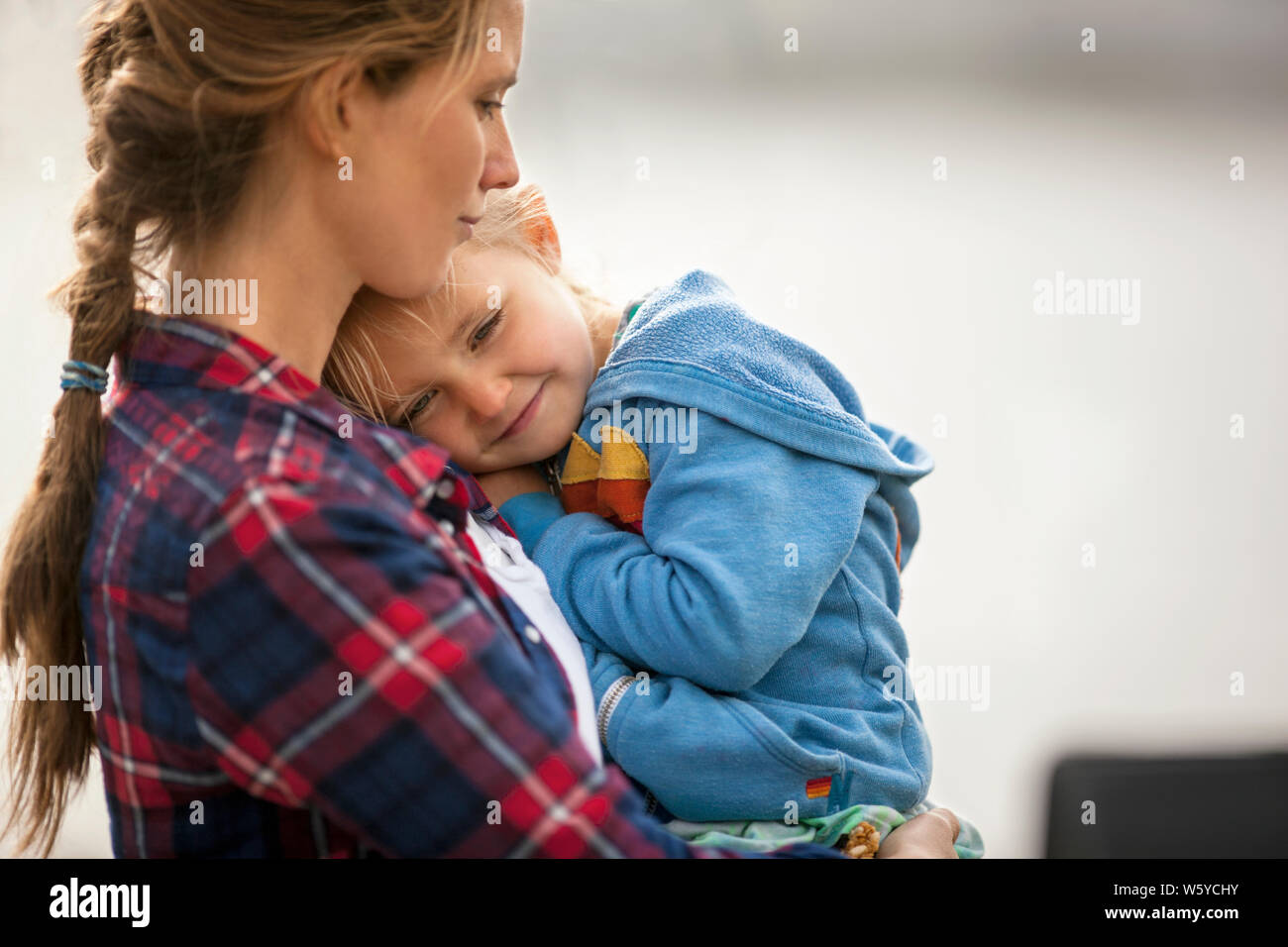 Lächelnd kleine Mädchen sich glücklich in die Arme der Mutter. Stockfoto