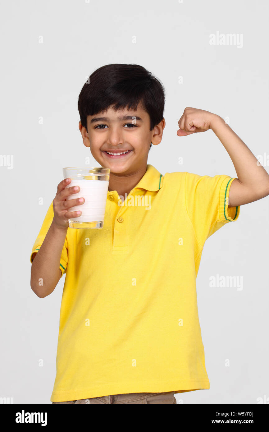 Junge hält ein Glas Milch und Muskeln Stockfoto