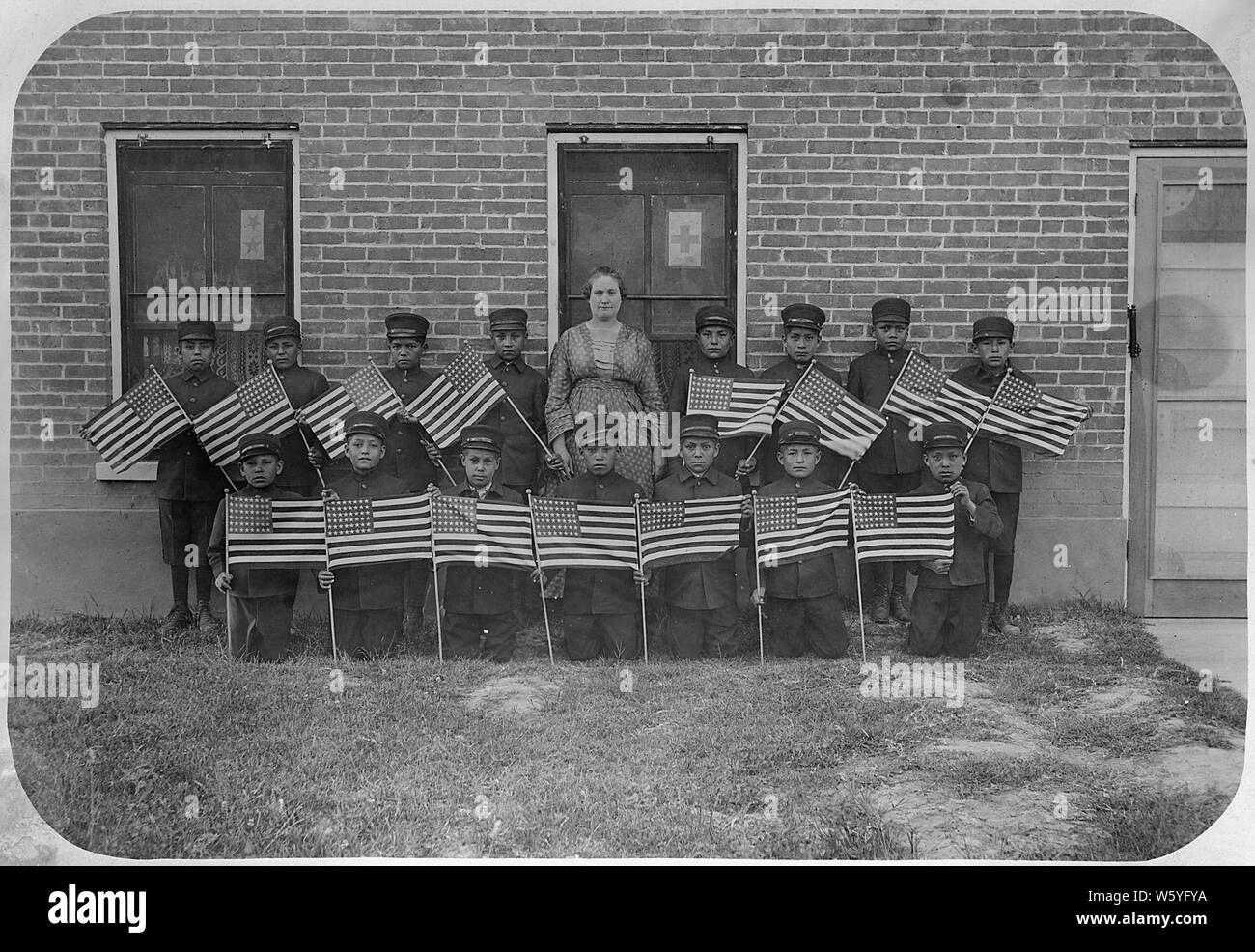 Sehr früh Klasse der jungen Jungen mit Fahnen am Albuquerque indischen Schule.; Umfang und Inhalt: Dies ist eine kleine Sammlung von Fotos der Albuquerque Indian School, das 1881 gegründet wurde, zur Verfügung zu stellen - Reservierung Industrial Training für die Indianer des Südwestens. Von 1912, hatte die Schule 8 Grundschule und über 300 Studenten; 1925 Immatrikulation stieg auf über 800 Schüler und Klassen 11 und 12 wurden hinzugefügt. Die Albuquerque Indian School contined in Betrieb, bis 1982, als das Programm wurde an der Santa Fe indischen Schule übertragen. Stockfoto