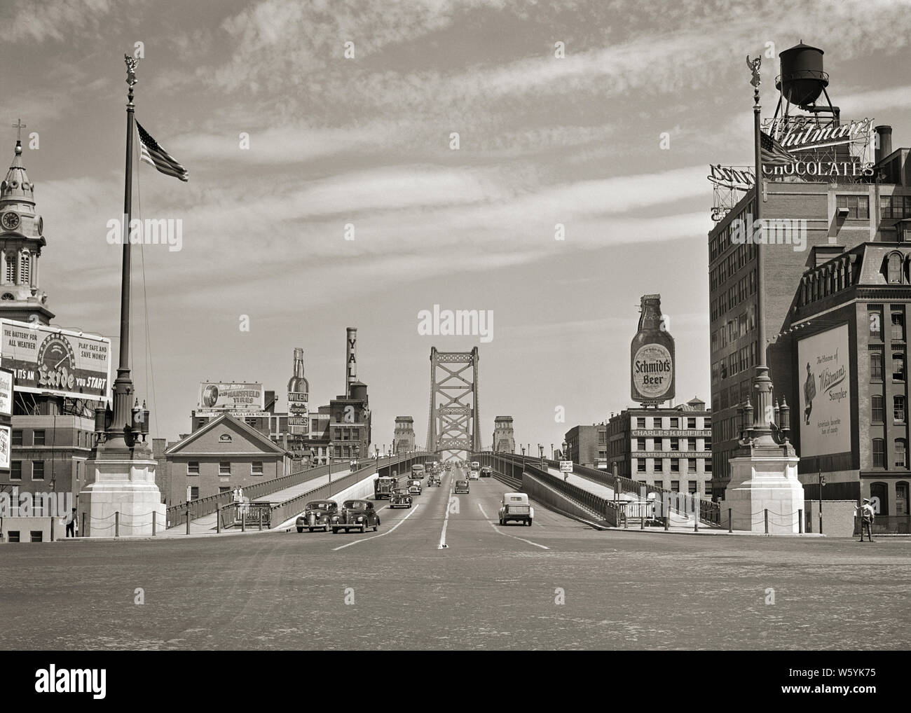 1920er Auto VERKEHR Ben Franklin Brücke zuerst genannten DELAWARE RIVER BRIDGE 1926 VON CAMDEN NJ IN PHILADELPHIA PA USA-b 11455 HAR 001 HARS VERBINDUNG KONZEPTIONELLER ÜBER AUTOMOBILE STILVOLLE FAHRZEUGE VERBINDEN NEW JERSEY BENJAMIN FRANKLIN BRIDGE DELAWARE RIVER ROT weiße und blaue Sterne und Streifen schwarze und weiße Kabel KABEL STADTBILD HAR 001 ALTMODISCH SUSPENSION BRIDGE Stockfoto