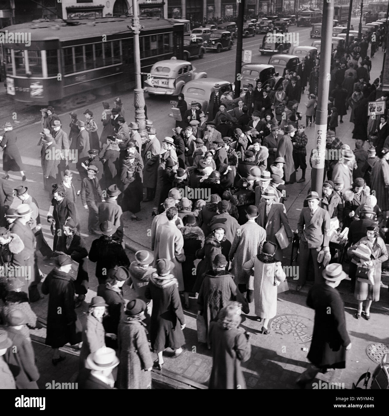 1930er Jahre besetzt MASSE MÄNNER UND FRAUEN FUSSGÄNGER STADT STRASSENKREUZUNGEN AUTOS UND TROLLY IM HINTERGRUND PHILADELPHIA PA USA-c 1073 HAR 001 HARS MÄNNER ECKE FUSSGÄNGER TRANSPORT B&W NORDAMERIKA NORDAMERIKA WEITWINKEL HOHEN WINKEL ABENTEUER Schnittpunkt und PA-RICHTUNG IM TAXI KONZEPTIONELLE ESCAPE WÄHLER SCHWARZE UND WEISSE BÜRGER HAR 001 ALTMODISCHEN TROLLEY ÜBERLASTET Stockfoto