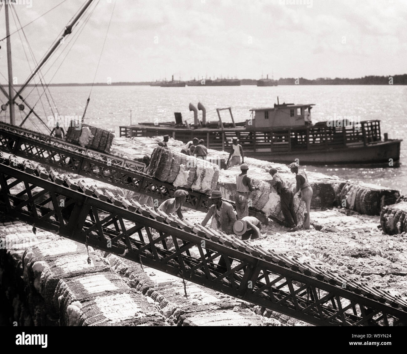 1930er Jahre TEAM DER AFRIKANISCHEN AMERIKANISCHEN MÄNNERN STAUER Entladen der Ballen Baumwolle VON MISSISSIPPI RIVER BARGE NEW ORLEANS LOUISIANA USA-c 6297 HAR 001 HARS KÖRPERLICHE FITNESS PERSONEN SCHWERE MÄNNER RISIKO BERUF TRANSPORT LANDWIRTSCHAFT B&W SCHLEIFRING LADEN WEITWINKEL SKILL BERUF FÄHIGKEITEN MANUELLER STÄRKE ENTLADEN afrikanische Amerikaner, Afrikaner - amerikanische Karriere leistungsstarke FORTSCHRITTE SCHWARZ ETHNIZITÄT ARBEIT LOUISIANA Stolz der Berufe, für die konzeptionelle Unterstützung zurück, die Ballen Mitte - Mitte - erwachsenen Mann RIVERBOAT VERSAND STAUER ZWEISAMKEIT WATERFRONT BALLEN BARGE SCHWARZ UND WEISS HAR 001 LA ARBEITER MISSISSIPPI RIVER Stockfoto