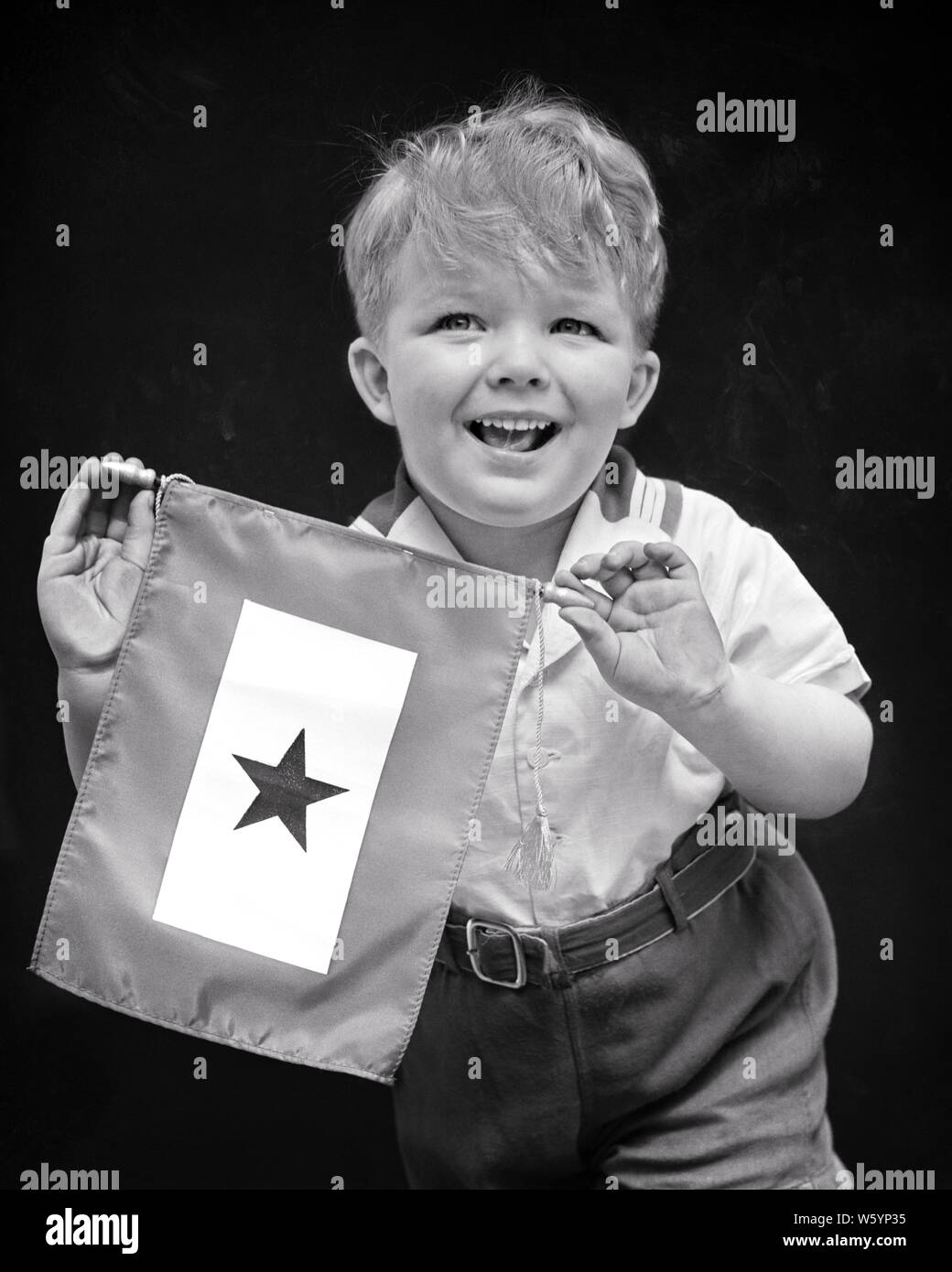 1940 s STOLZ LÄCHELND JUNGE RELATIVE HOLDING BLUE STAR SERVICE BANNER ZEIGT EIN FAMILIENMITGLIED, DAS IN DER US-Weltkrieg-II-d 1665 HAR 001 HARS GESICHTSBEHANDLUNG KOMMUNIKATION INFORMATIONEN SÖHNE GERNE FAMILIEN FREUDE LIFESTYLE GESCHICHTE FEIER STOLZ ANZEIGE STUDIO SHOT LÄNDLICHEN LEBEN ZU HAUSE UNITED STATES KOPIE RAUM MIT HALBER LÄNGE INSPIRATION VEREINIGTE STAATEN VON AMERIKA MÄNNER RISIKO AUSDRÜCKE B&W NORDAMERIKA AUGENKONTAKT NORDAMERIKANISCHEN fröhliche Kraft, Mut, Stolz den ZWEITEN WELTKRIEG IN LÄCHELT UNIFORMEN KONZEPTIONELLE FREUDIGE STILVOLLE FAMILIENMITGLIEDER JUGENDLICHE DIE RELATIVE ZWEISAMKEIT SCHWARZ UND WEISS Stockfoto