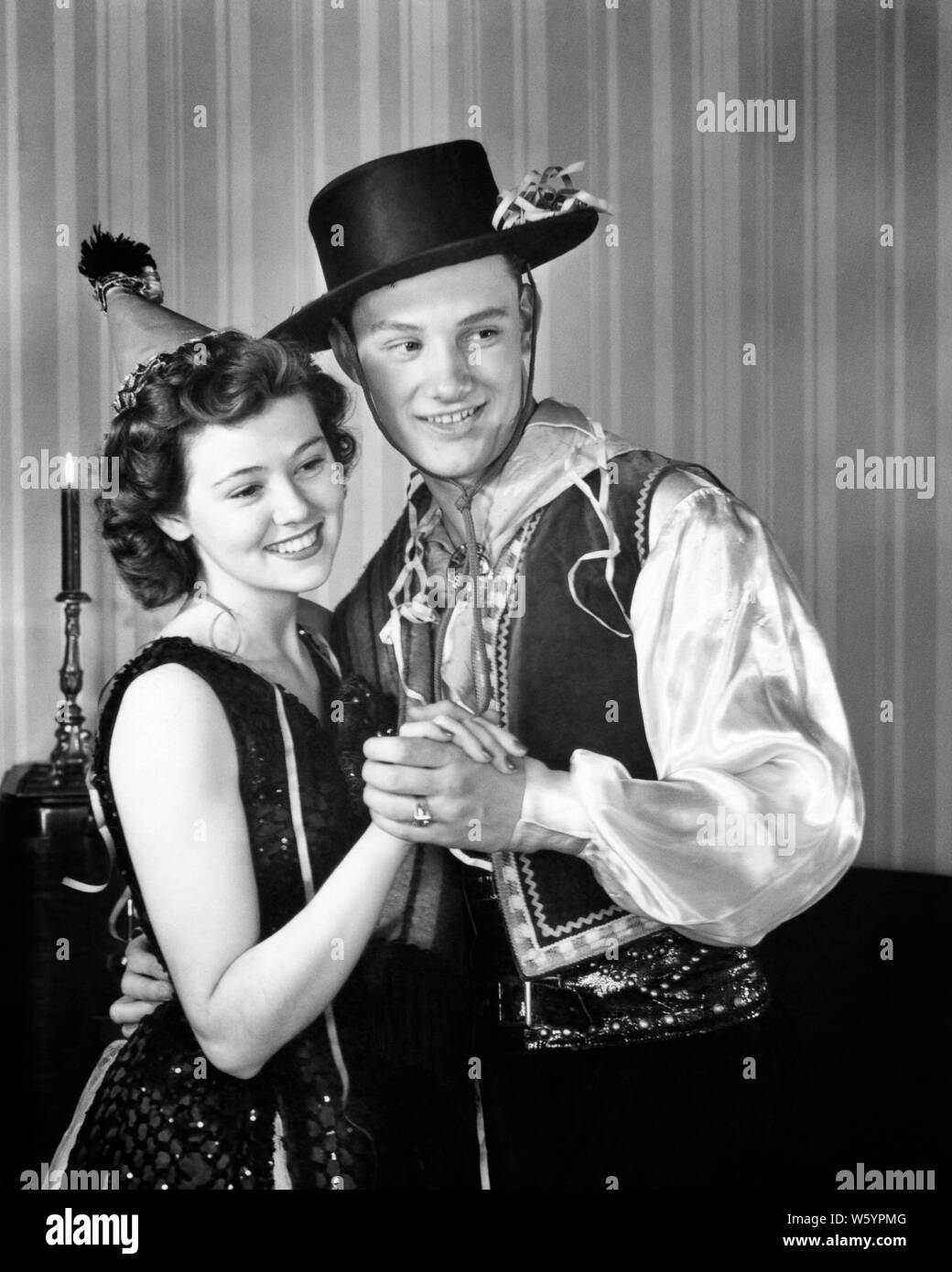 1940 LÄCHELNDE PAAR MANN UND FRAU TANZEN ZUSAMMEN AN KOSTÜM PARTY-d 891 HAR 001 HARS TÄNZER MAGIC OLD TIME ÜBERRASCHUNG NOSTALGIE OLD FASHION 1 dumme Gesicht Stil junger Erwachsener BALANCE COMIC TEAMARBEIT SPANISCH GERNE KOSTÜME FREUDE LIFESTYLE FEIER FRAUEN GEHEIRATET STUDIO SHOT EHEPARTNER EHEMÄNNER GESUNDHEIT FREUNDSCHAFT IN VOLLER LÄNGE mit halber Länge DAMEN PERSONEN INSPIRATION MÄNNER UNTERHALTUNG AUSDRÜCKE B&W PARTNER TRÄUME HUMORVOLL GLÜCK FRÖHLICHE FREIZEIT UND ERHOLUNG KOMISCHE ZEICHEN WAHL AUFREGUNG BEI LÄCHELN KONZEPTIONELLE KOMÖDIE FANTASIE FREUDIGE STILVOLLE GAY HARLEKIN KREATIVITÄT PARTNER Stockfoto