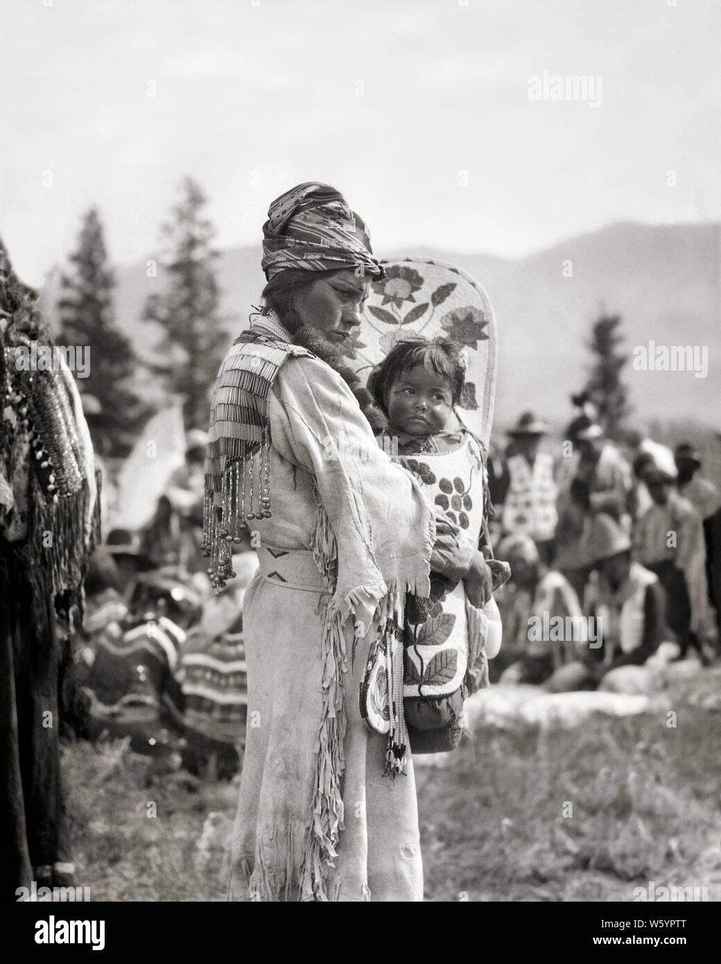 1920er Jahre 1930er Jahre NATIVE AMERICAN STONEY SIOUX INDIANISCHE FRAU MUTTER IN PERLEN HIRSCHLEDER KLEID HOLDING BABY JUNGE MÄDCHEN IN PAPOOSE KANADA - ich 59 HAR 001 HARS FRAUEN IM LÄNDLICHEN LEBEN ZU HAUSE KOPIEREN RAUM IN VOLLER LÄNGE mit halber Länge DAMEN PERSONEN TRADITIONELLE INDER B&W NORDAMERIKA NORDAMERIKA HIRSCHLEDER RÜCKANSICHT IN KONZEPTIONELLEN PAPOOSE NATIVE AMERICAN BABY BOY STONEY SIOUX RÜCKANSICHT HIRSCHLEDER GESÄUMTEN jugendliche Mitte nach Mitte der erwachsenen Frau Mammen gebürtige Amerikaner BABY GIRL PERLEN schwarzes und weißes Kind TRÄGER CRADLE BOARD HAR 001 INDIGENEN ALTMODISCH Stockfoto