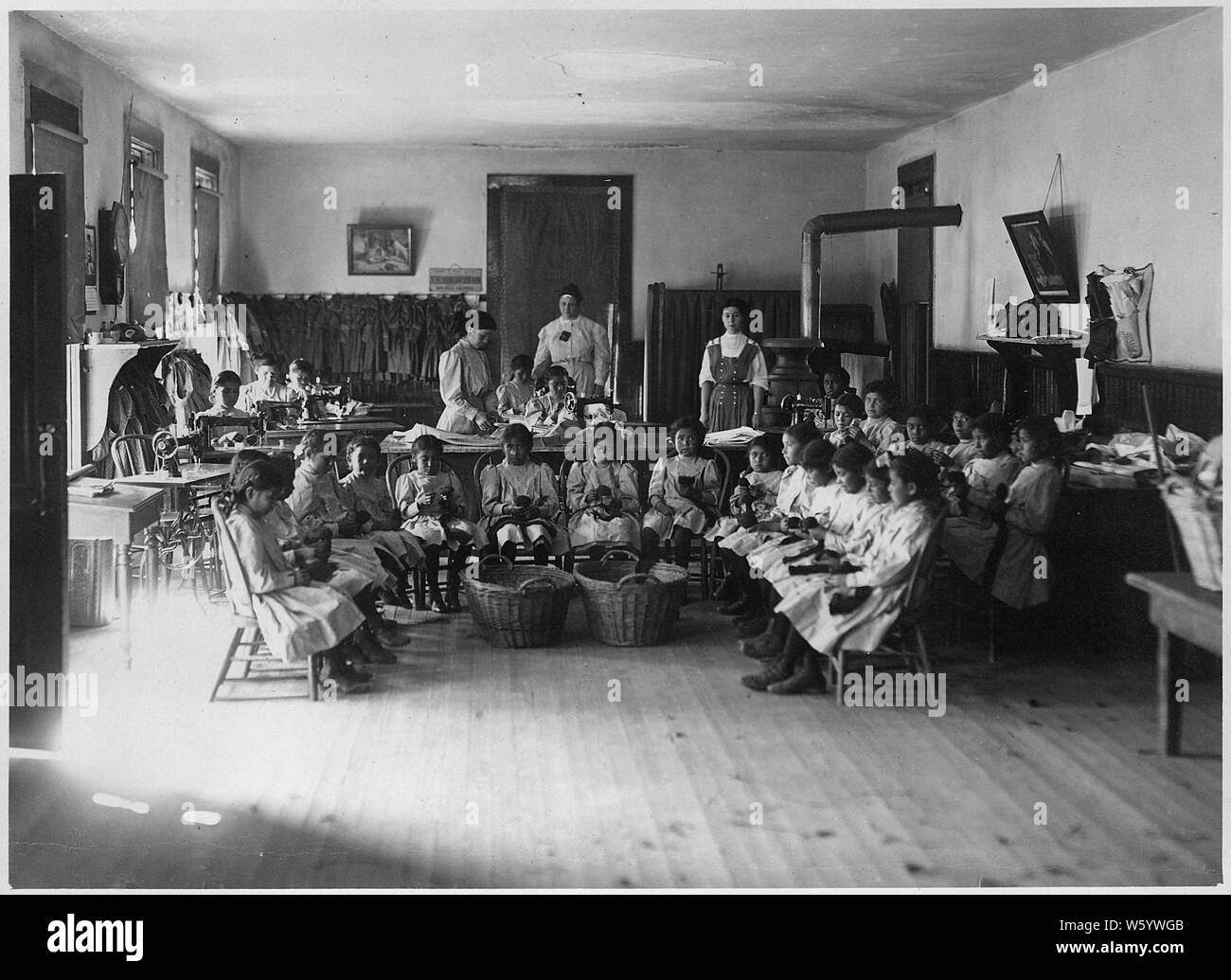 Junge Schule grirls Teilnahme an nähen Klasse in Albuquerque indischen Schule.; Umfang und Inhalt: Dies ist eine kleine Sammlung von Fotos der Albuquerque Indian School, das 1881 gegründet wurde, zur Verfügung zu stellen - Reservierung Industrial Training für die Indianer des Südwestens. Von 1912, hatte die Schule 8 Grundschule und über 300 Studenten; 1925 Immatrikulation stieg auf über 800 Schüler und Klassen 11 und 12 wurden hinzugefügt. Die Albuquerque Indian School contined in Betrieb, bis 1982, als das Programm wurde an der Santa Fe indischen Schule übertragen. Stockfoto