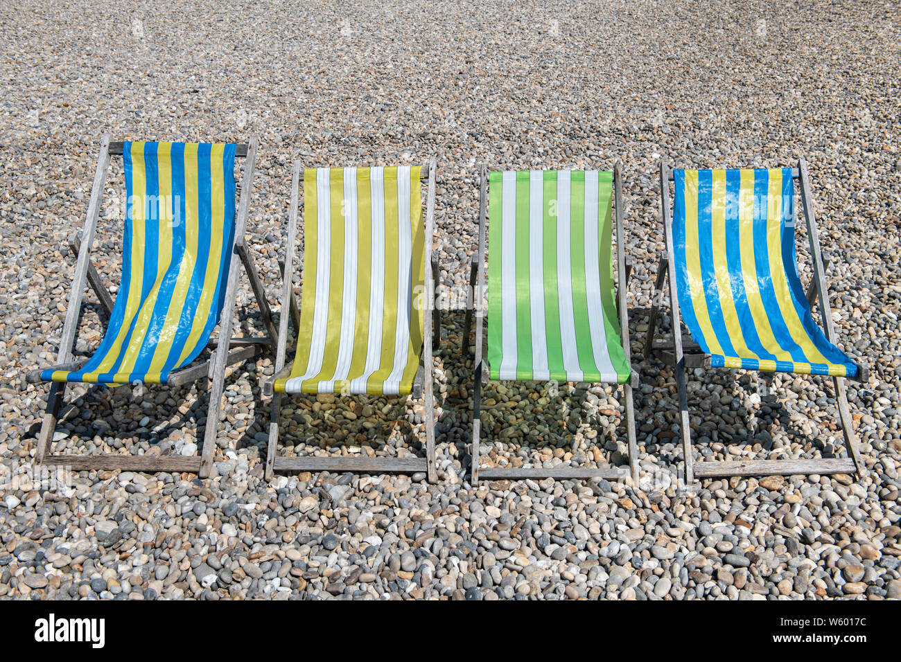 Vier leeren Liegestühlen sitzen auf Bier Beach in Mitte Sommer. Stockfoto