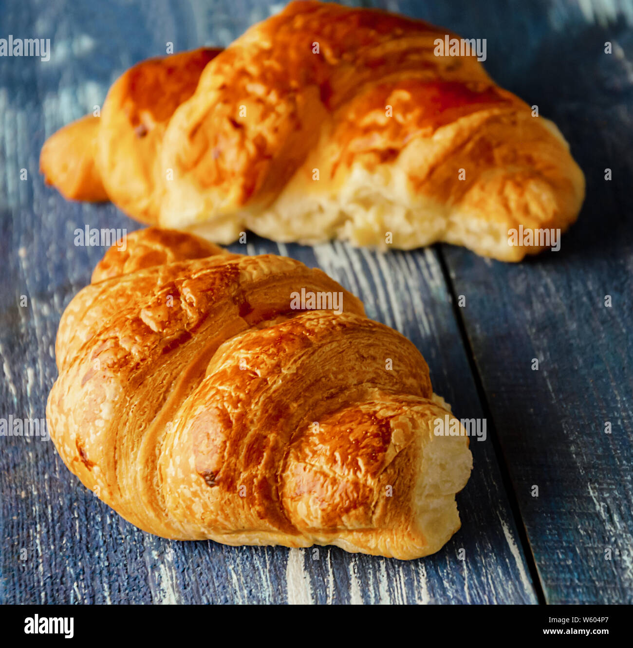 Croissants auf einem blauen Hintergrund Holz, leckeres Gebäck mit einem rötlichen scharfe Nahaufnahme Stockfoto