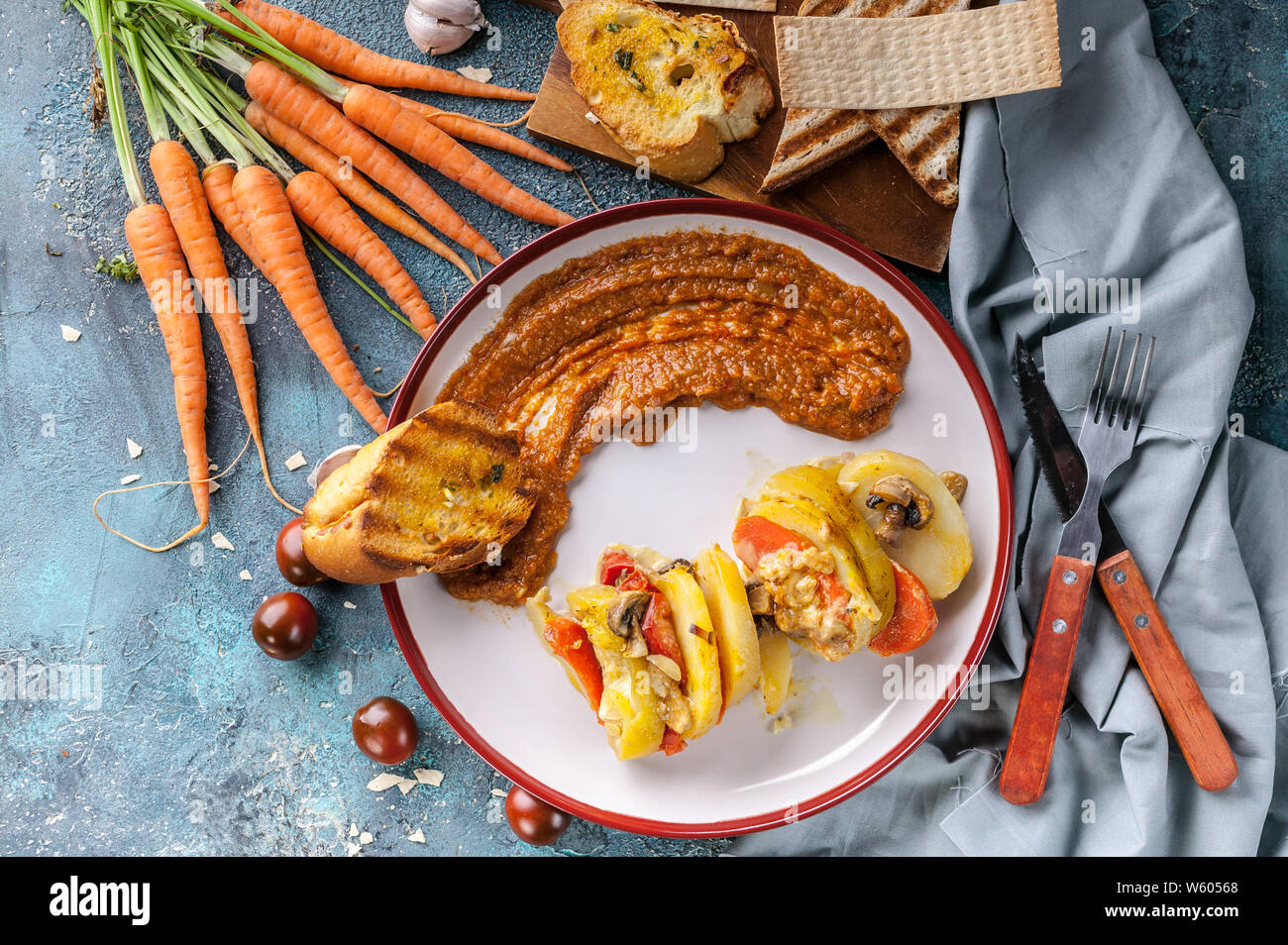 Vegetarisches Essen. Geschmorte Kartoffeln mit Zucchini, Karotten, Champignons und Käse. Karotten Püree mit Champignons. Ansicht von oben Stockfoto