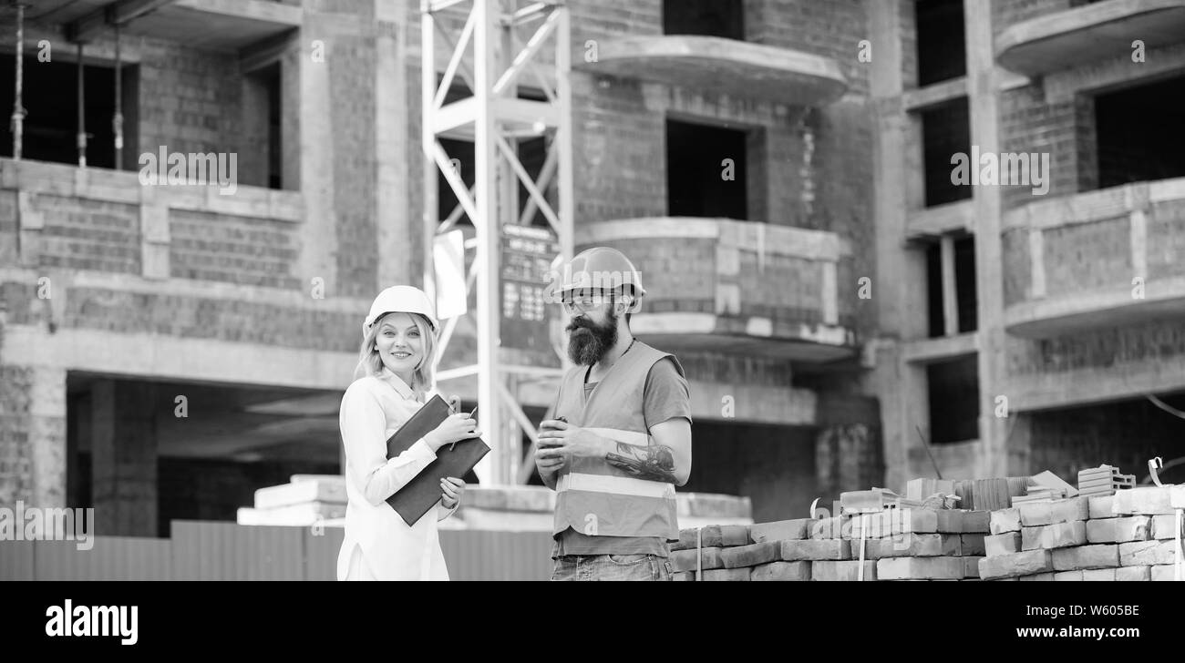 Bau team Kommunikationskonzept. Beziehungen zwischen den Kunden und Teilnehmer. Frau Ingenieur und brutale Builder kommunizieren Baustelle Hintergrund. Stockfoto