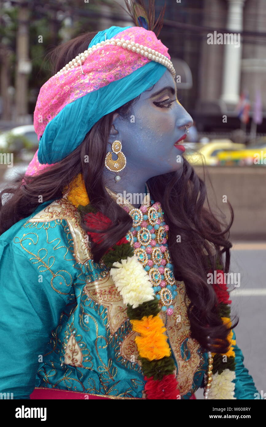 Eine Frau, die Tänzer in einem farbenfrohen Umzug durch die Internationale Gesellschaft für Krishna-bewusstsein (ISKCON) in Bangkok, Thailand, am 7. Juli 2019. Die Parade begann an der indischen Handelskammer auf Sathorn Soi 1 und fuhr nach unten Sathorn Road. Die Hare Krishna Bewegung oder Hare Krishnas, ist ein Gaudiya Vaishnava Hinduistische religiöse Organisation in 1966 in New York City gegründet von A.C. Bhaktivedanta Swami Prabhupada, der Guru und spirituellen Meister der Organisation. Stockfoto