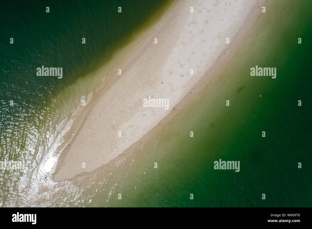 Antenne drone Blick auf einen kleinen Sandstrand am Spieß durch ein grünes, warmen tropischen Ozean umgeben Stockfoto