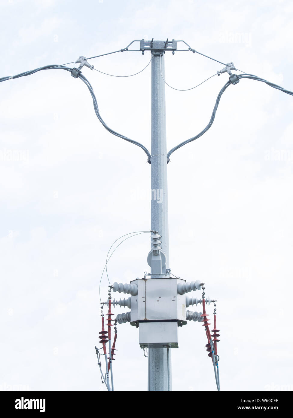 Moderne drei Phase-Verteilertrafos auf einer hohen Spannung elektrische Pole. Weißen Himmel Hintergrund Stockfoto