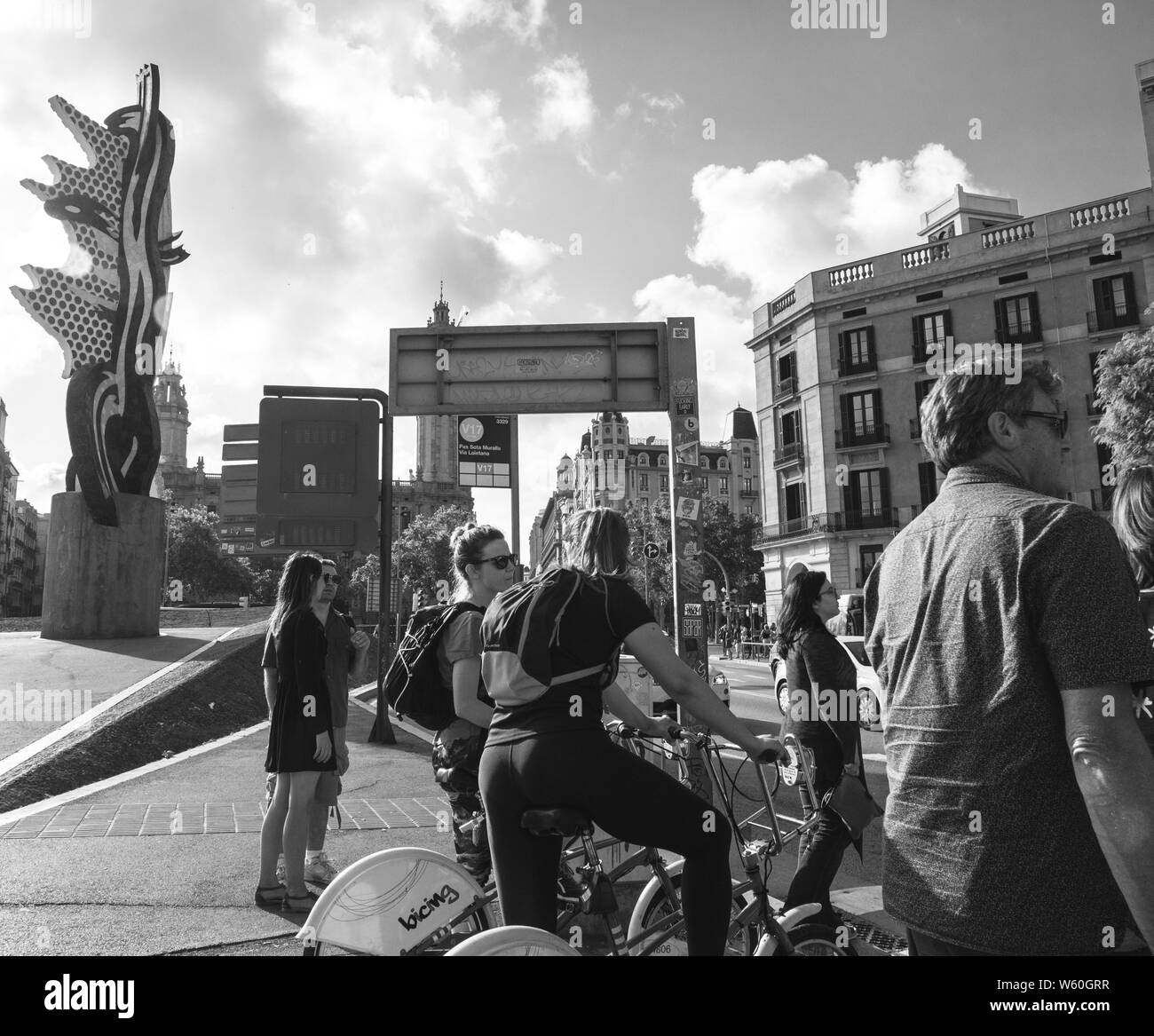 Barcelona, Spanien - Jun 1, 2018: Fußgänger Männer und Frauen Radfahrer warten die geschäftigen Pas Sota Muralla Straße bei Sonnenuntergang zu überqueren - Schwarz und Weiß Stockfoto